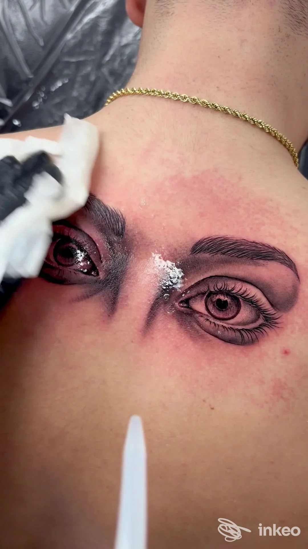 Tatuaggio realistico di due occhi sulla nuca, lavoro in corso presso Kindergarten Studio a Varazze.
