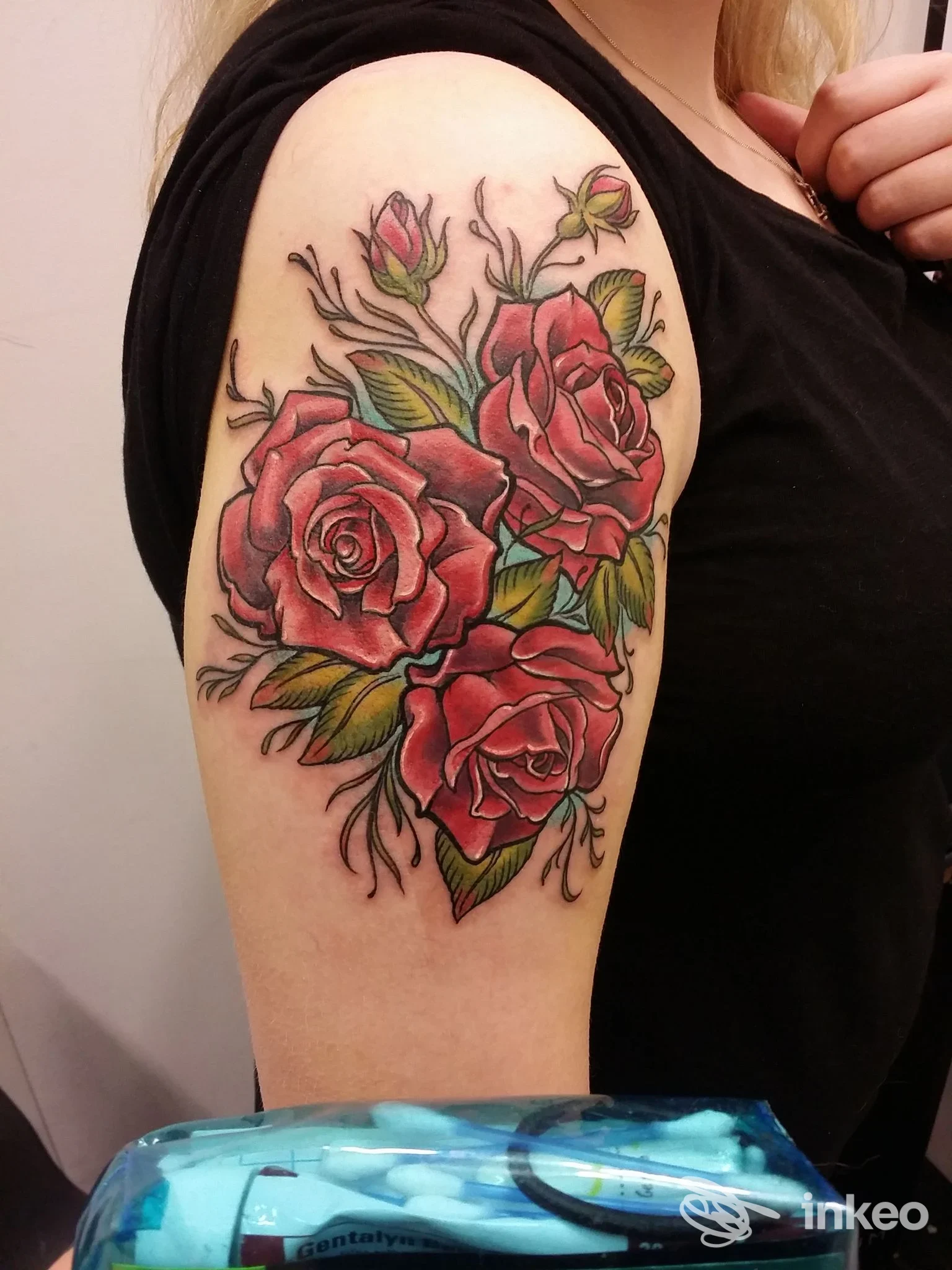 Tatuaggio sul braccio superiore con tre rose rosse e boccioli in stile neo-traditional, realizzato da The Tattoo Gallery a Bussolengo.
