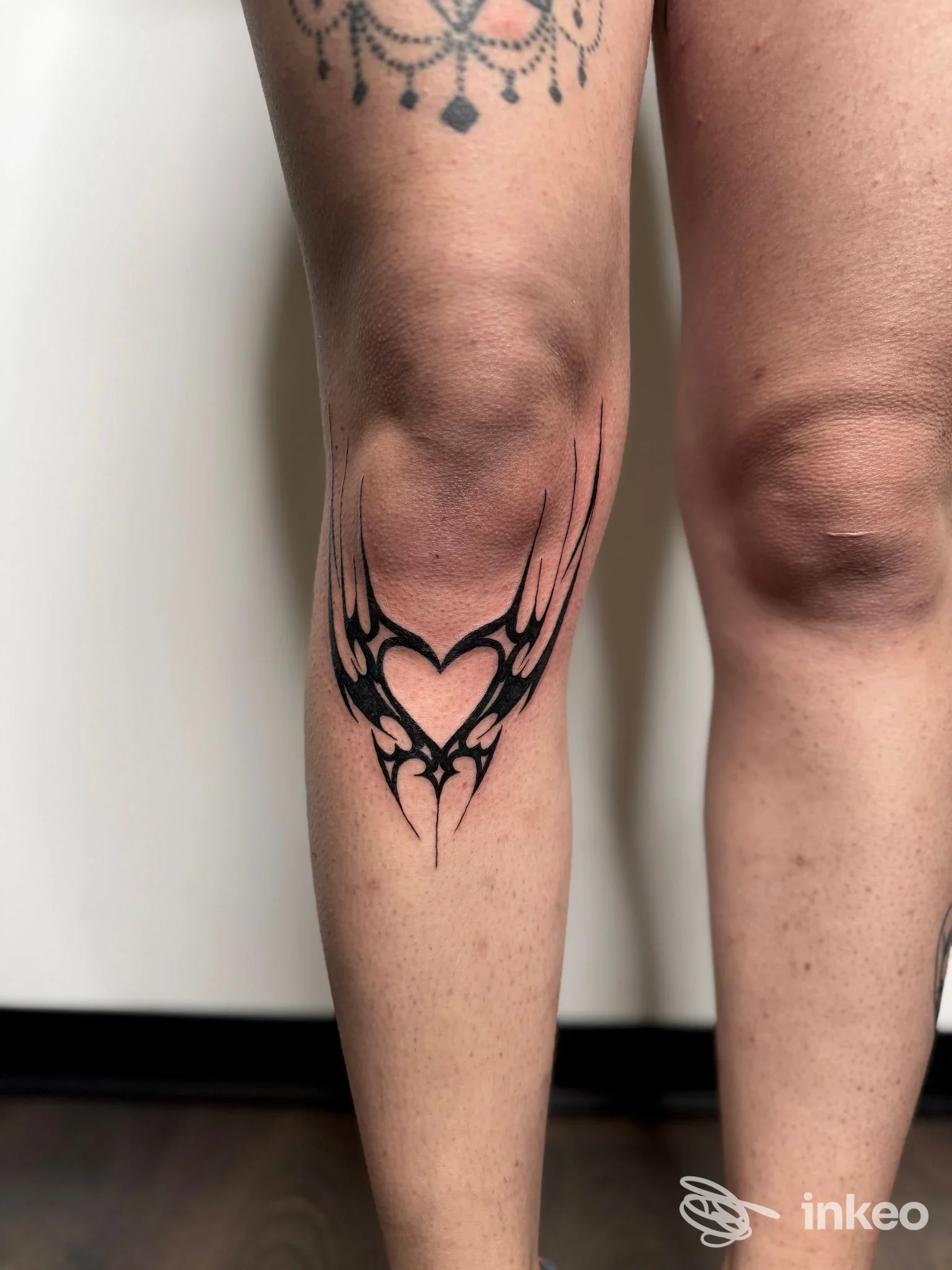 Tatuaggio nero a forma di cuore con motivi simmetrici sul polpaccio sinistro, immagine fornita da Noeink a Pontecorvo.
