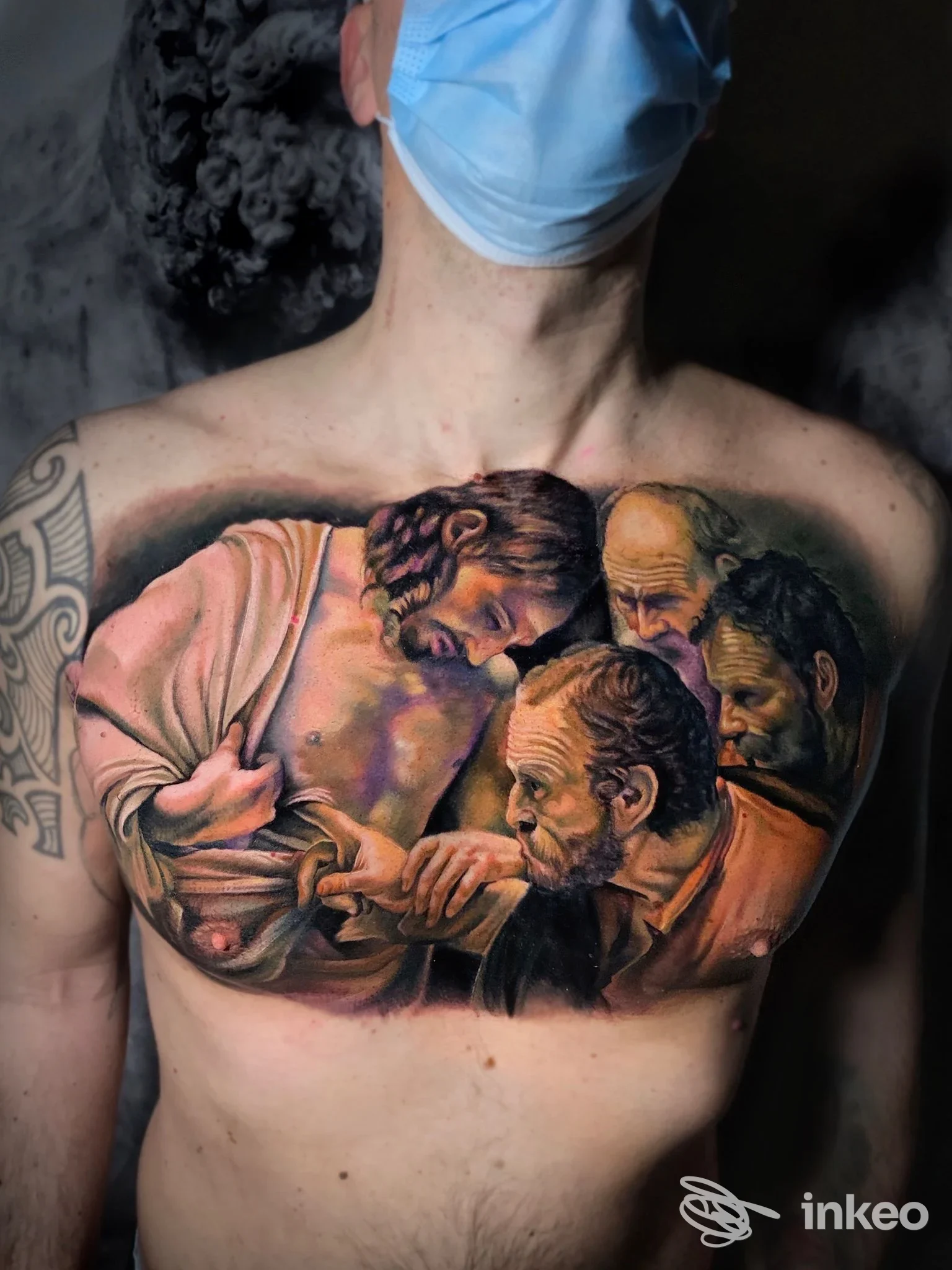 Ampio tatuaggio realistico a colori sul petto raffigurante volti figurativi, realizzato da Paul White Vision a Barletta.