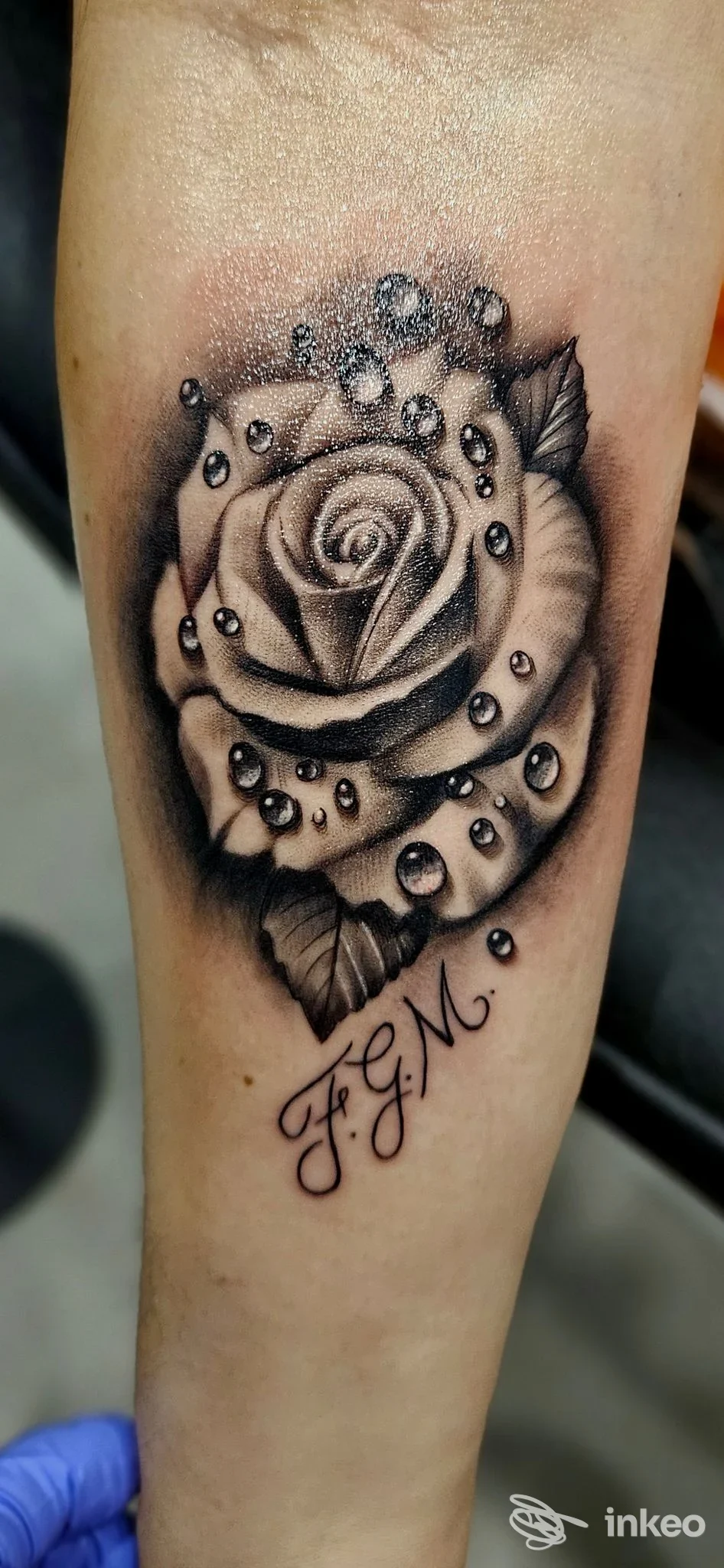 Tatuaggio realistico black & grey di una rosa con gocce e iniziali sul avambraccio — Red Rose Tattoo Studio, Modugno.