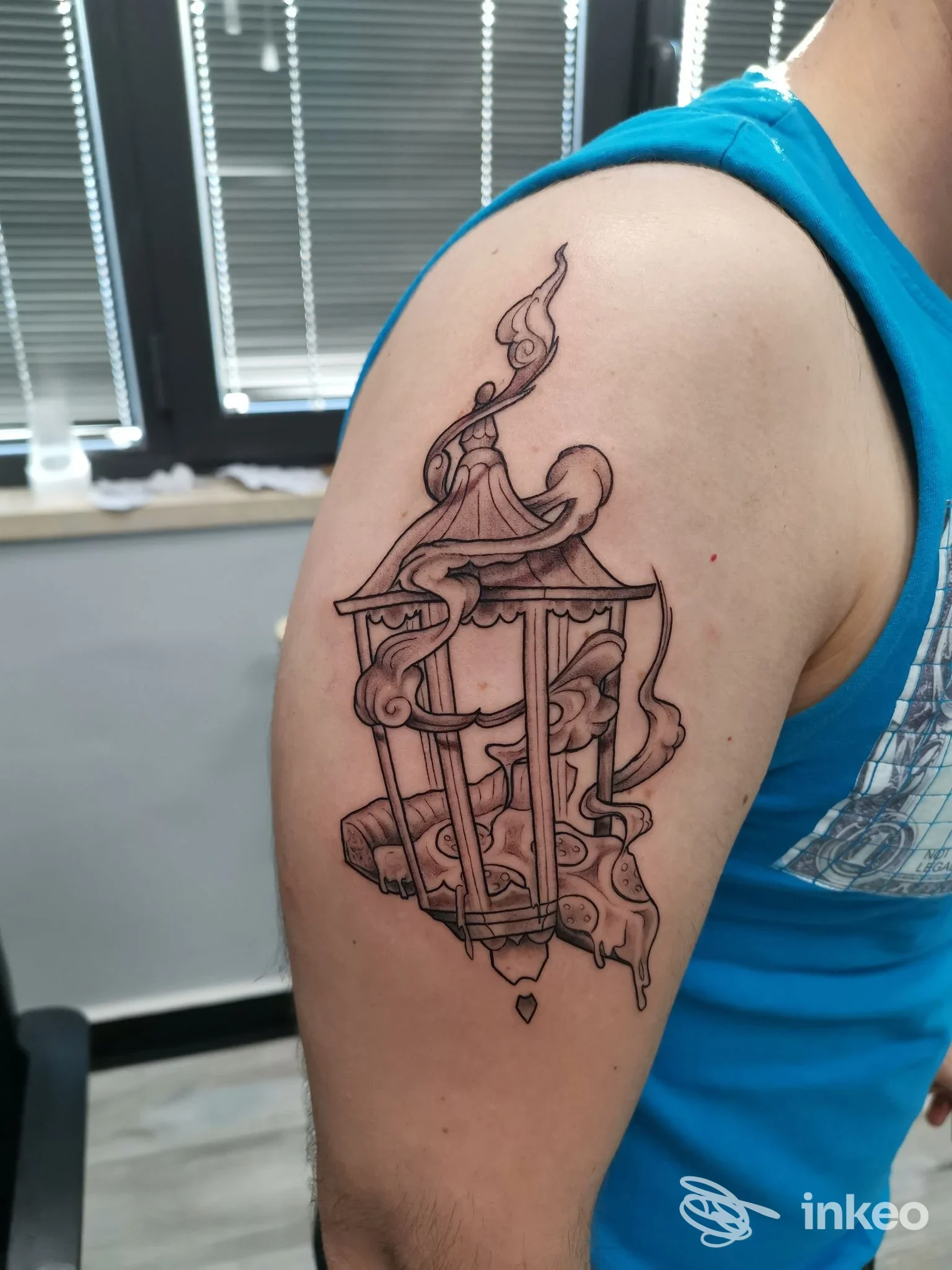 Tatuaggio nero su braccio superiore raffigurante una lanterna stilizzata con fumo, foto per Erion Tattoo di Meca Erion, Ripi.