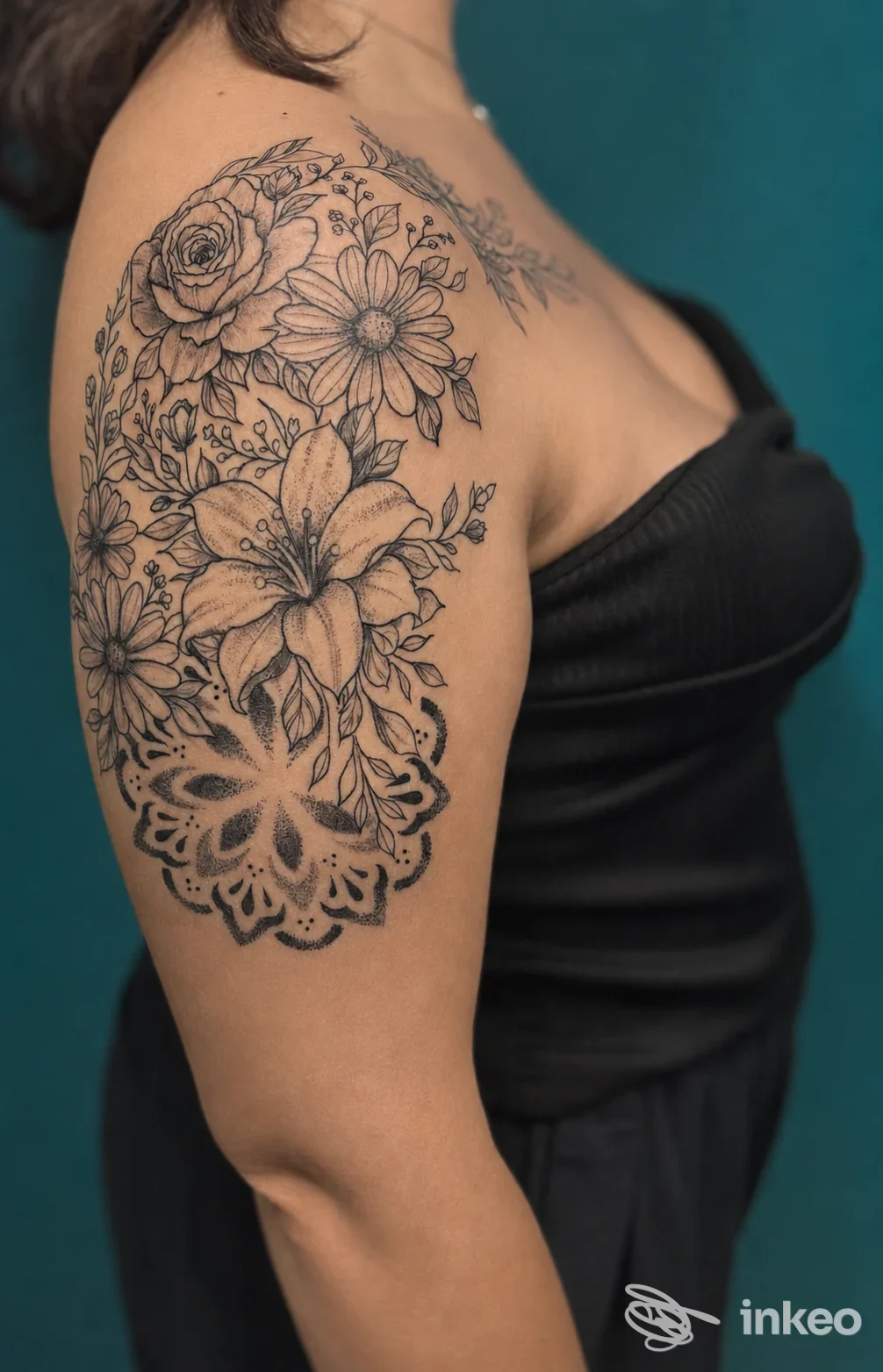 Grande tatuaggio floreale in bianco e nero sulla spalla e il braccio superiore, realizzato da Br.ink tattoo a Sora.