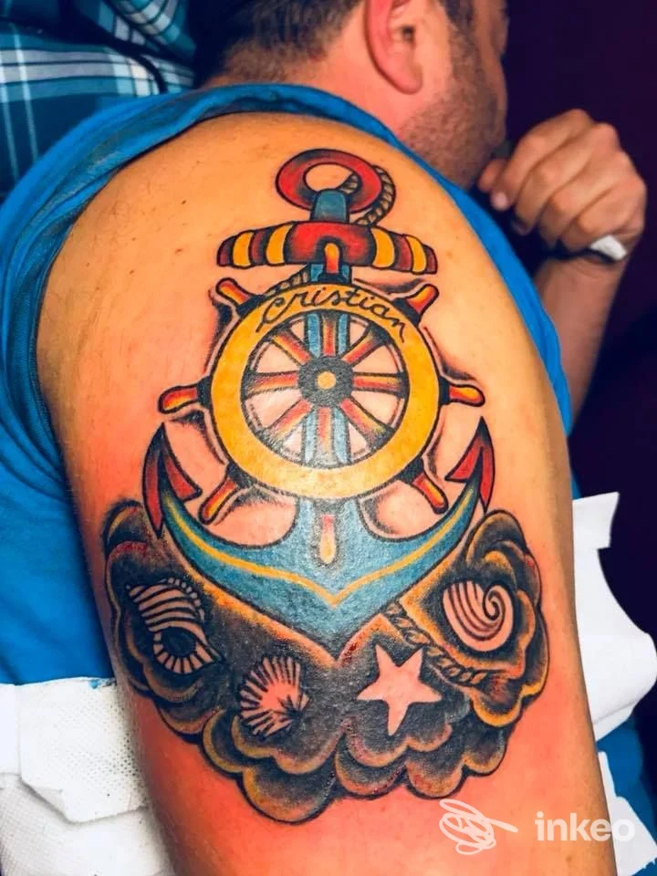 Tatuaggio nautico colorato sull'omero di un cliente realizzato da Titti Tattoo a Viterbo, dettaglio a colori nitido e contrastato.