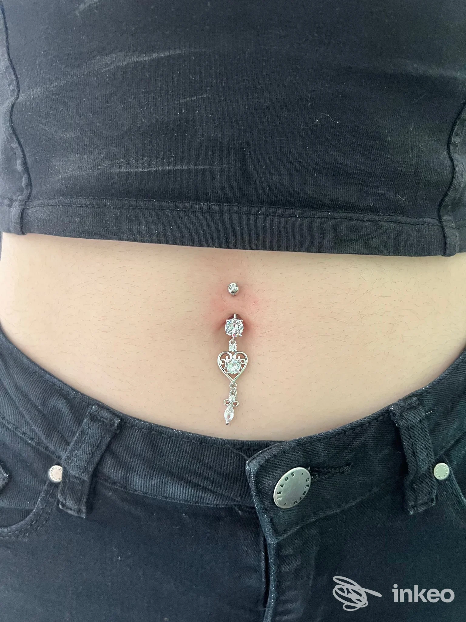 Piercing ombelicale con pendente in metallo e strass, foto ritratto dell'addome per Derma Room Nuoro, Nuoro.