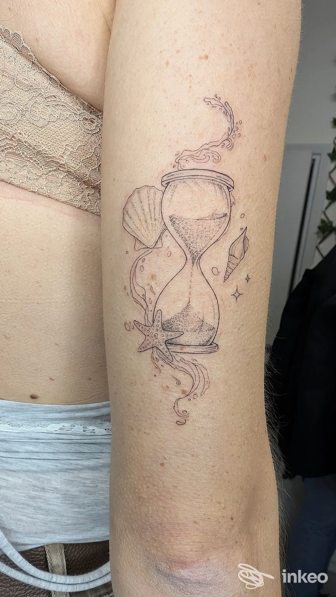 Tatuaggio a clessidra in stile linework sul braccio, foto caricata dallo studio Sal7tattoo di Carrara.