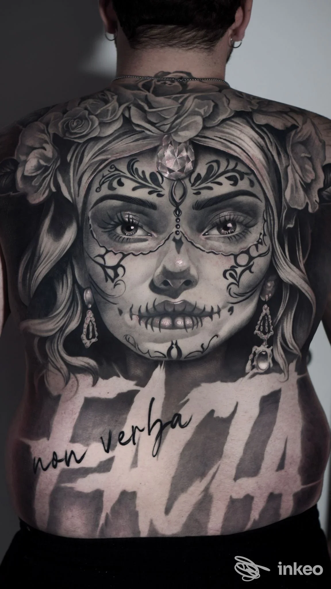 Grande tatuaggio in bianco e nero sul dorso raffigurante volto stile sugar skull con rose e scritte; Z Tattoo Shop, Bari.