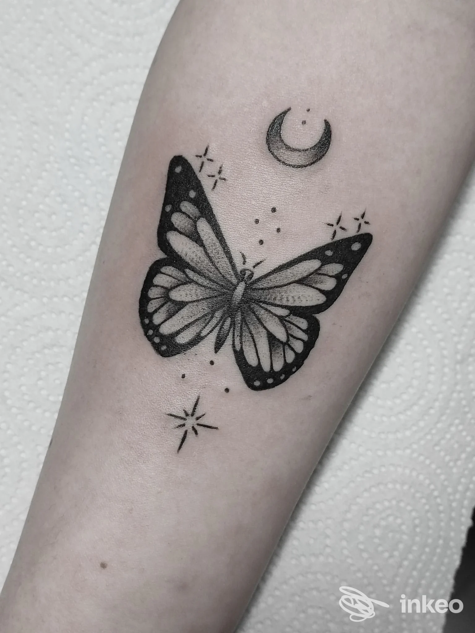 Tatuaggio farfalla in bianco e nero sull'avambraccio con luna e stelline. Mino ink Tattoo Store, Mugnano di Napoli.