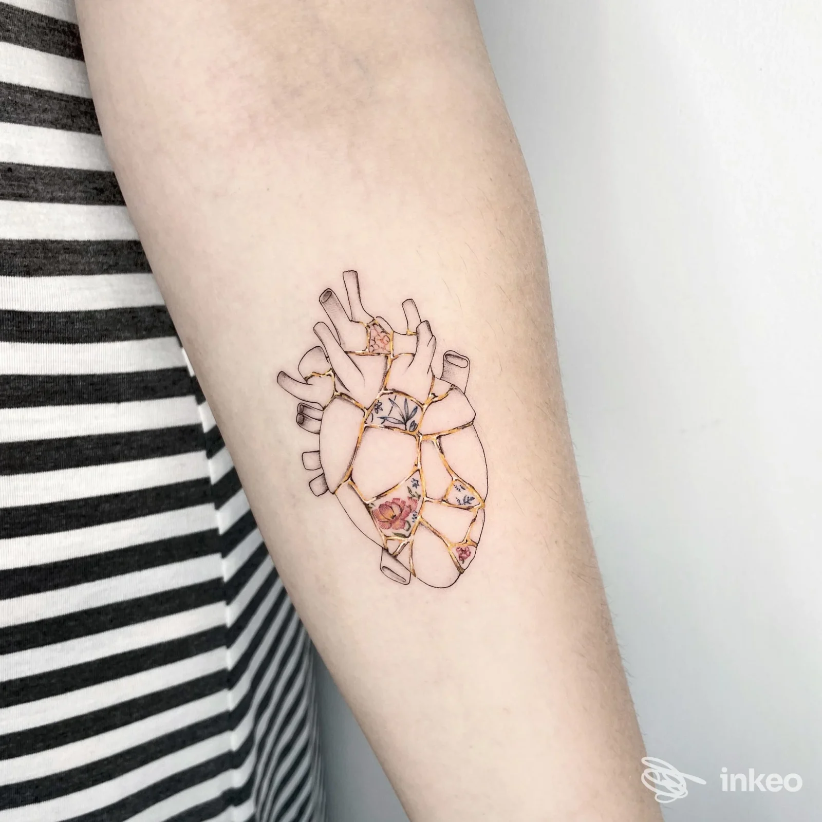 Tatuaggio su avambraccio: cuore anatomico con inserti floreali, Blind Garden Studio, Ravenna.