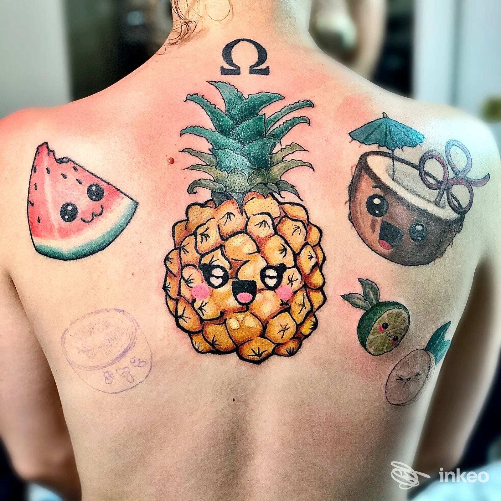 Dorso con vivaci tatuaggi kawaii, ananas centrale e altri soggetti colorati, foto fornita da Endo Tattoo a Bari.