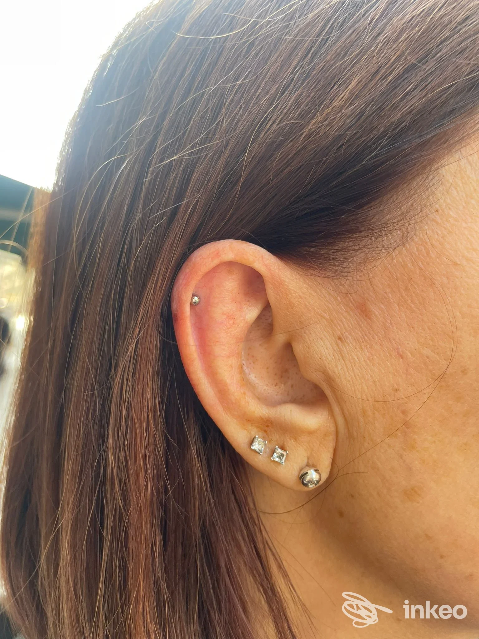 Piercing multipli sull'orecchio destro, realizzati da Piercing n More, foto ravvicinata che mette in evidenza i gioielli su lobo e cartilagine.