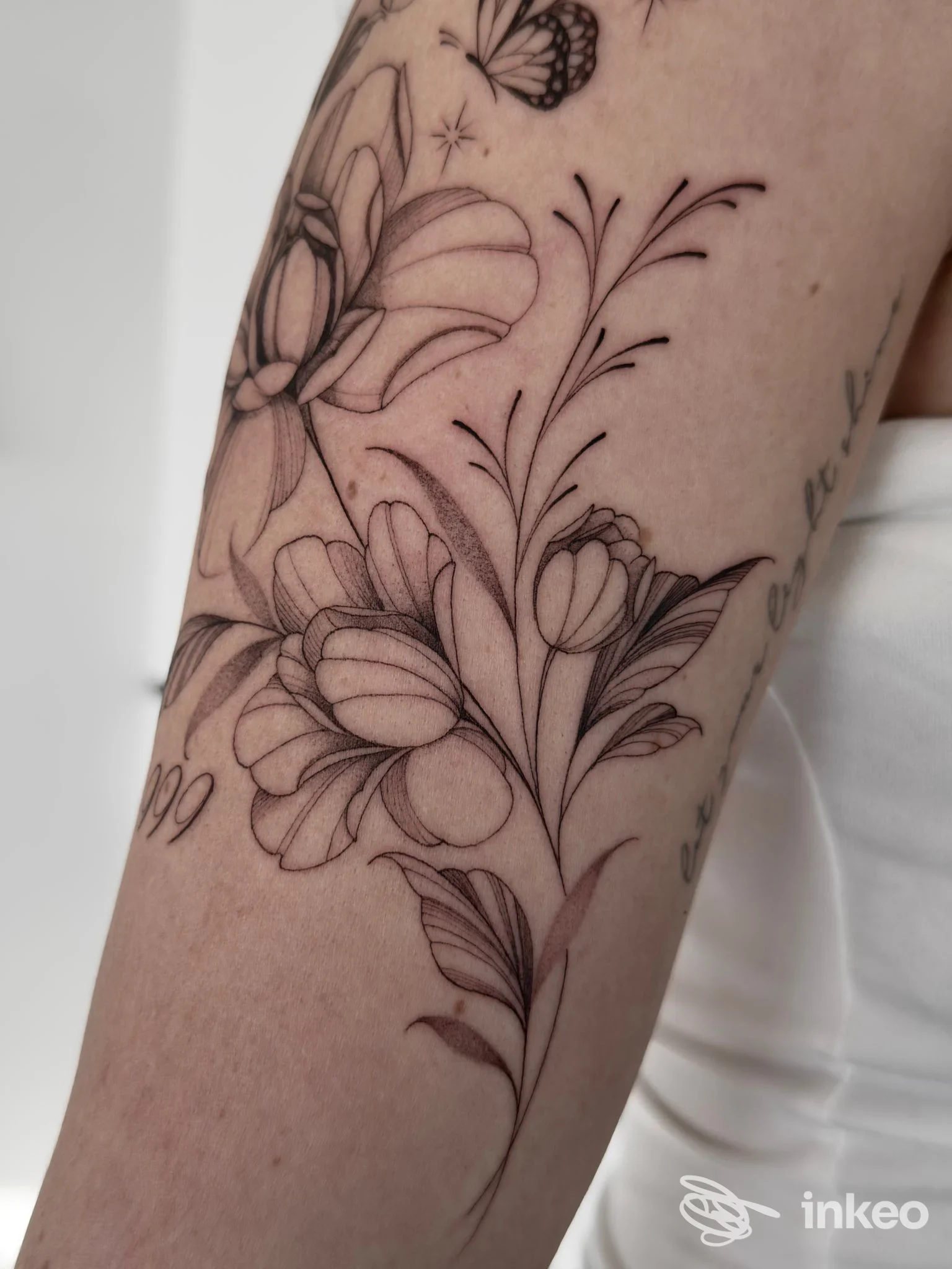 Dettaglio di tatuaggio floreale in linework sull'avambraccio, opera di Gate of Ink a Bressanone.