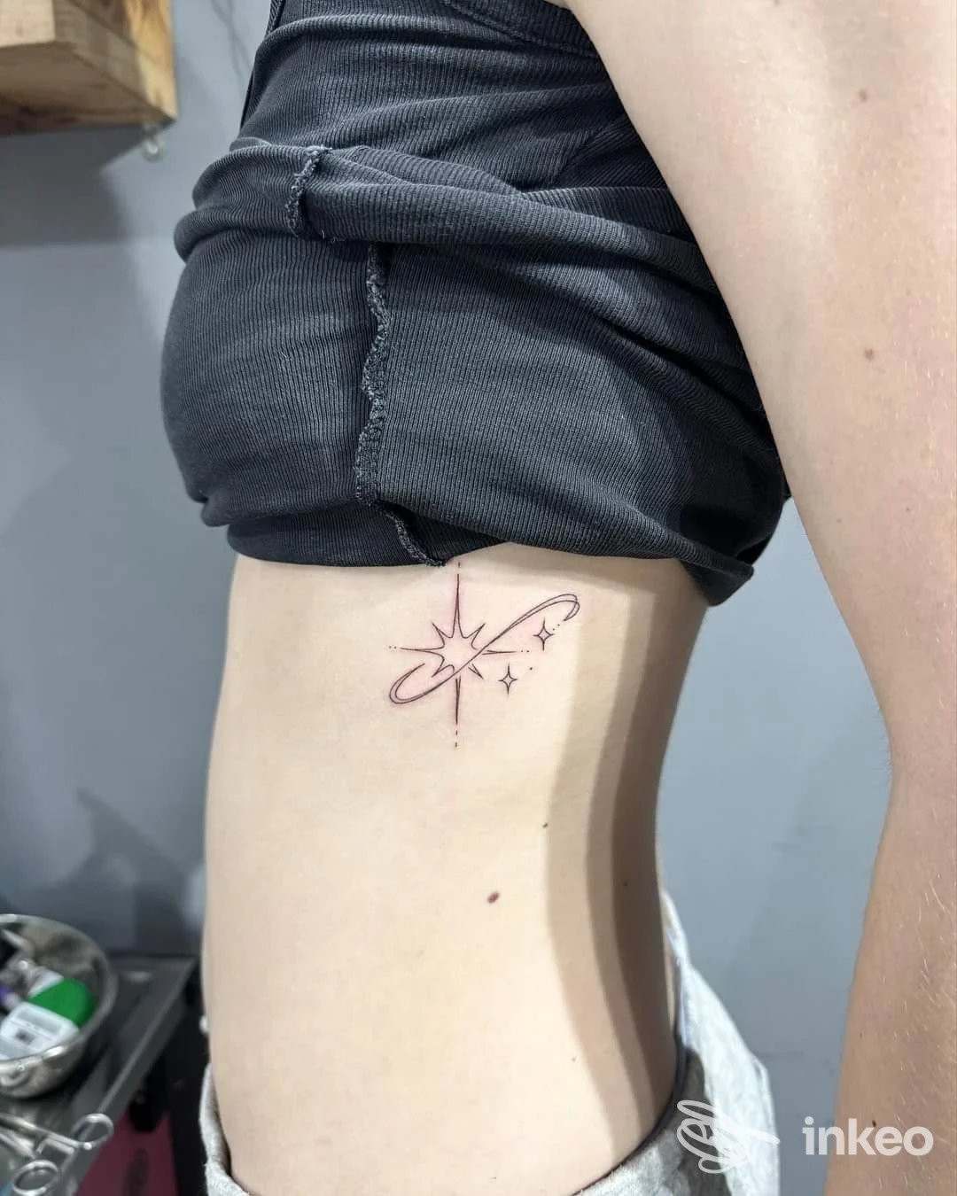 Tatuaggio minimale a linee sottili sul fianco destro, eseguito presso Samui Tattoo Museum a Mugnano di Napoli, motivo stellare con orbita.