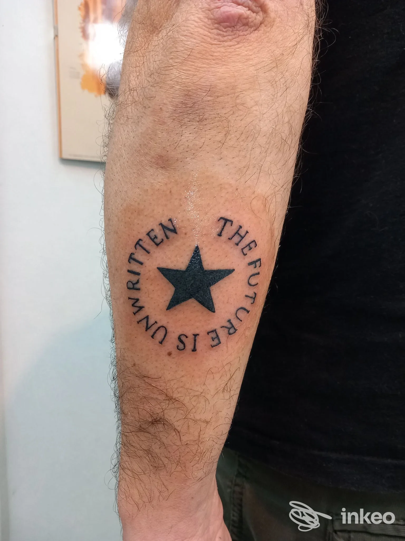 Tatuaggio a stella nera con scritta circolare sull'avambraccio, foto da Samui Tattoo Museum a Mugnano di Napoli.