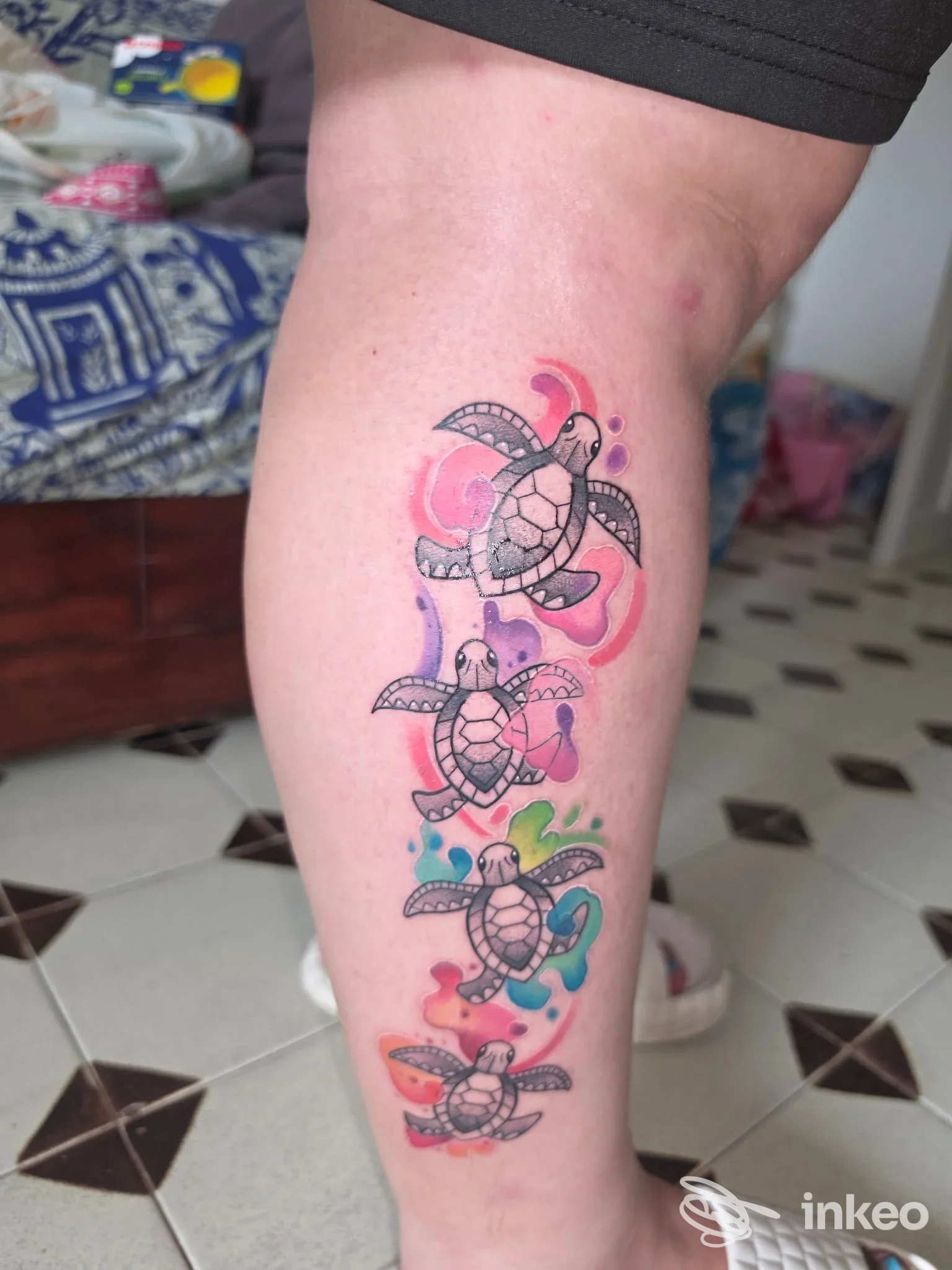 Tatuaggio su polpaccio con quattro tartarughe colorate in stile acquerello, fotografia inviata dallo studio Family Affair Tattoo Studio di Civitavecchia.