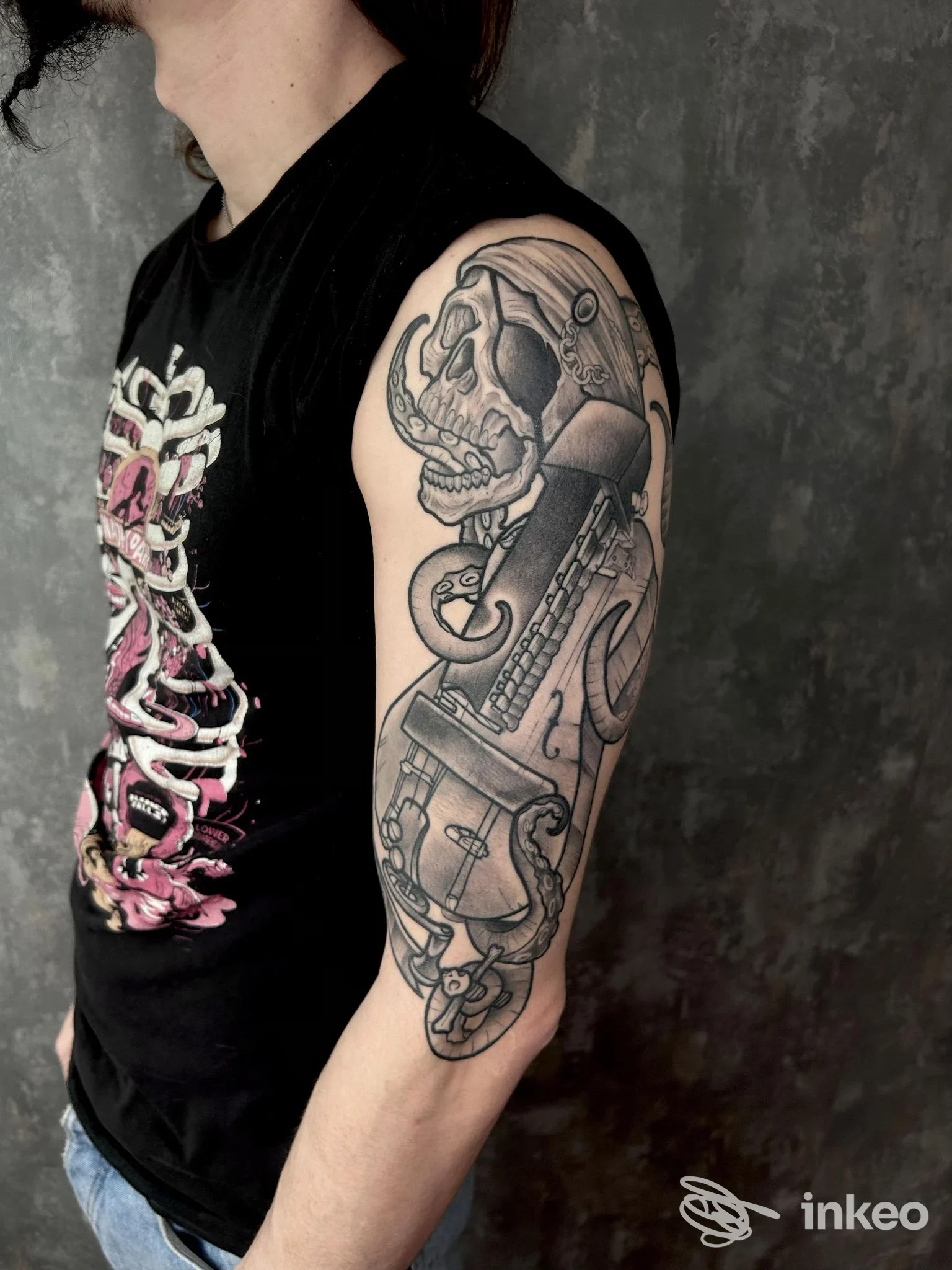 Tatuaggio in bianco e nero a manica parziale con teschio e strumenti sul braccio, Mystic Tattoo Studio, Russi.