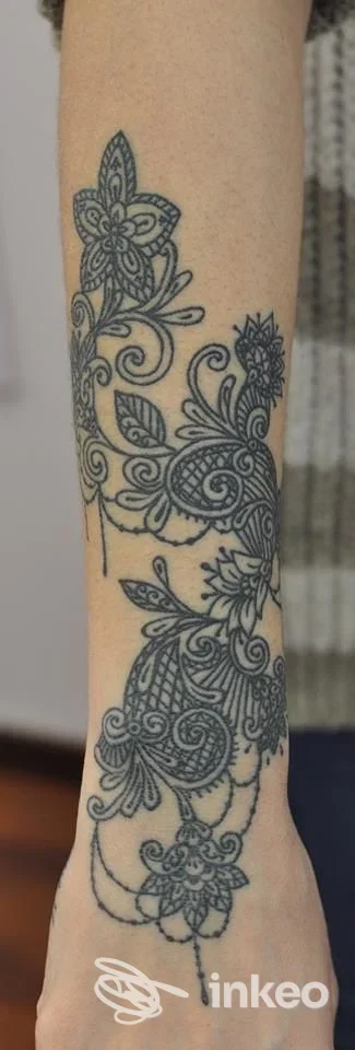 Ampio tatuaggio ornamentale floreale in nero su avambraccio, foto fornita da Mei Elisa Delicious Ink, Fano.