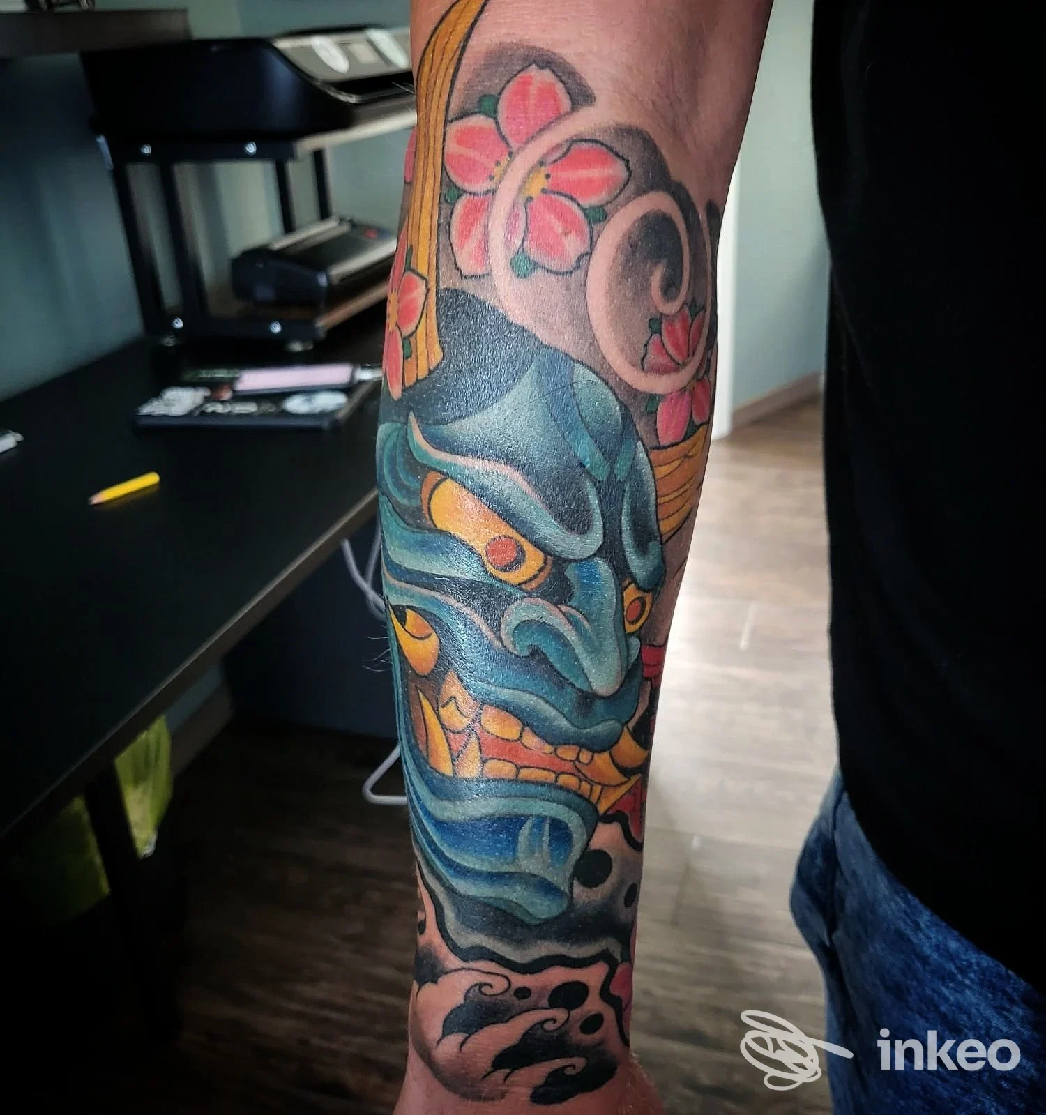 Tattoo artistico sul braccio in stile colorato, visibile su pelle reale presso Skin Painter Tattoo Shop, Albino, senza volto visibile nella foto.