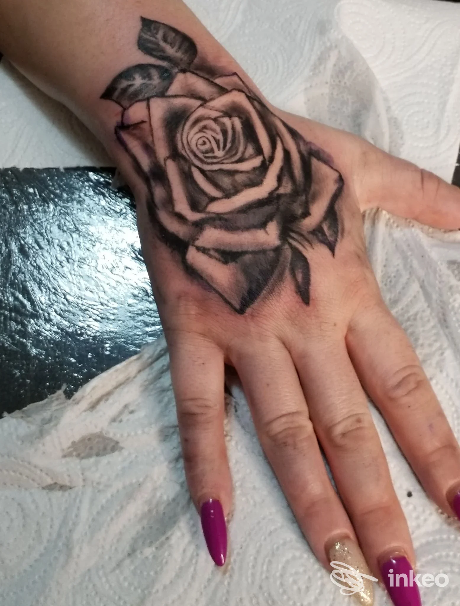 Rosa in bianco e nero tatuata sul dorso della mano; foto fornita da NataMancina Tattoo a Bisceglie.