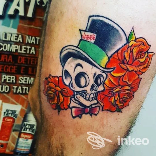 Tatuaggio su coscia: cranio con cilindro e rose arancioni, NataMancina Tattoo a Bisceglie.