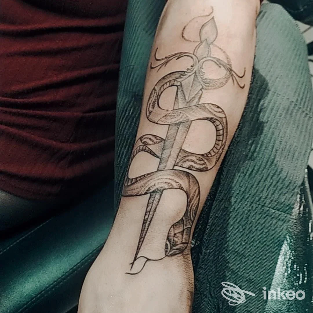 Dettaglio di un tatuaggio con serpente avvolto intorno a un pugnale sull'avambraccio, foto di NataMancina Tattoo, Bisceglie.