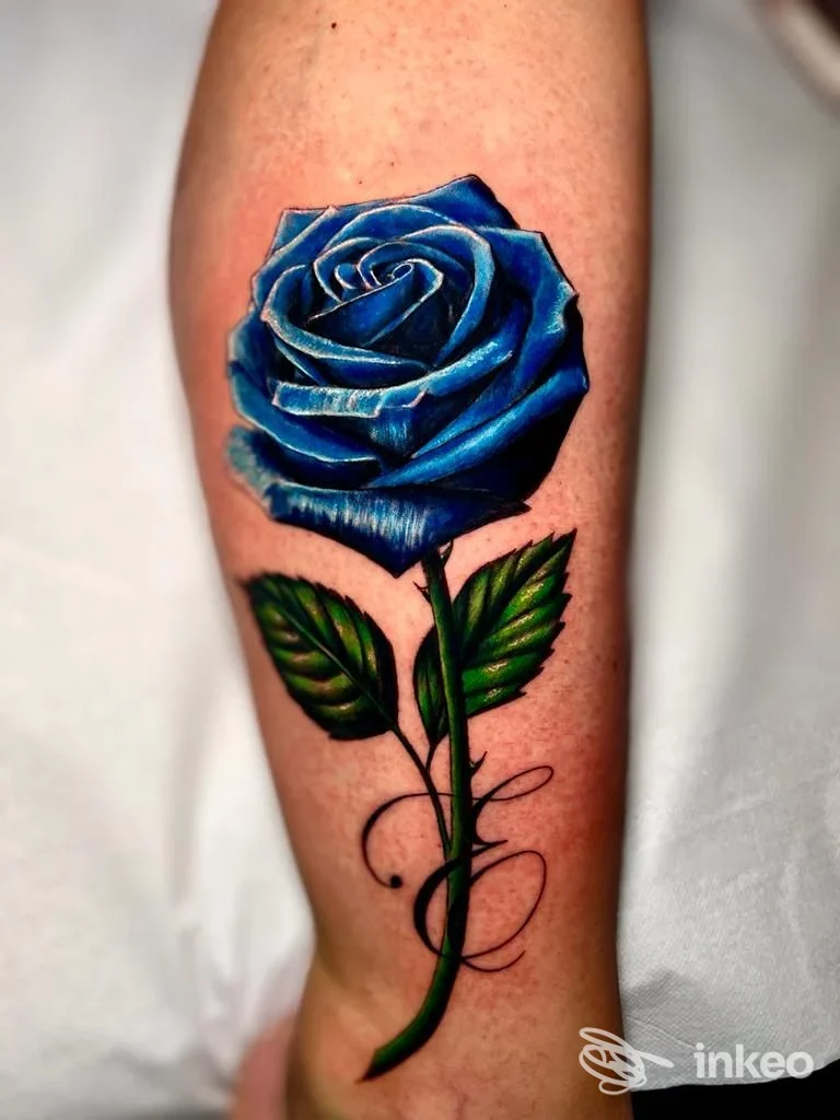 Rosa blu tatuata sull'avambraccio, con gambo e foglie verdi; foto inviata da Dark Moon Tattoo, Roma.