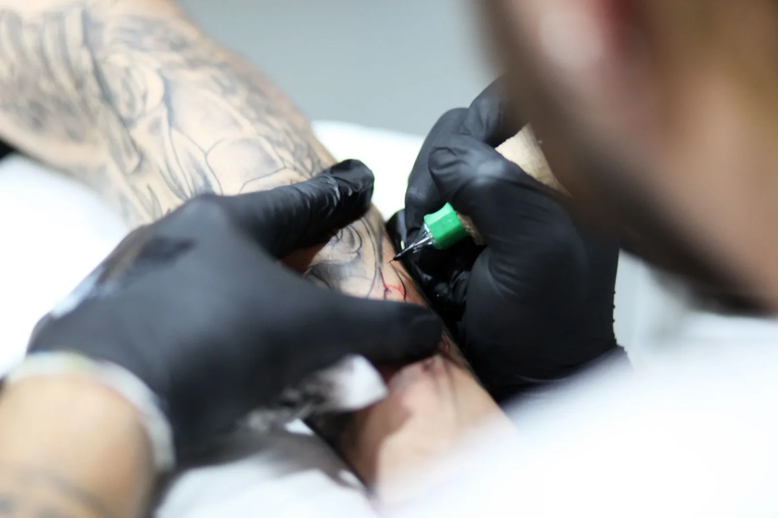 Artista al lavoro su un tatuaggio all'avambraccio, Mamma - tattoo, drink, design, Catanzaro.