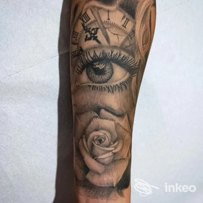 Tatuaggio realistico su avambraccio con occhio, orologio e rosa, foto fornita da Beauty&Tattoo a San Ferdinando.