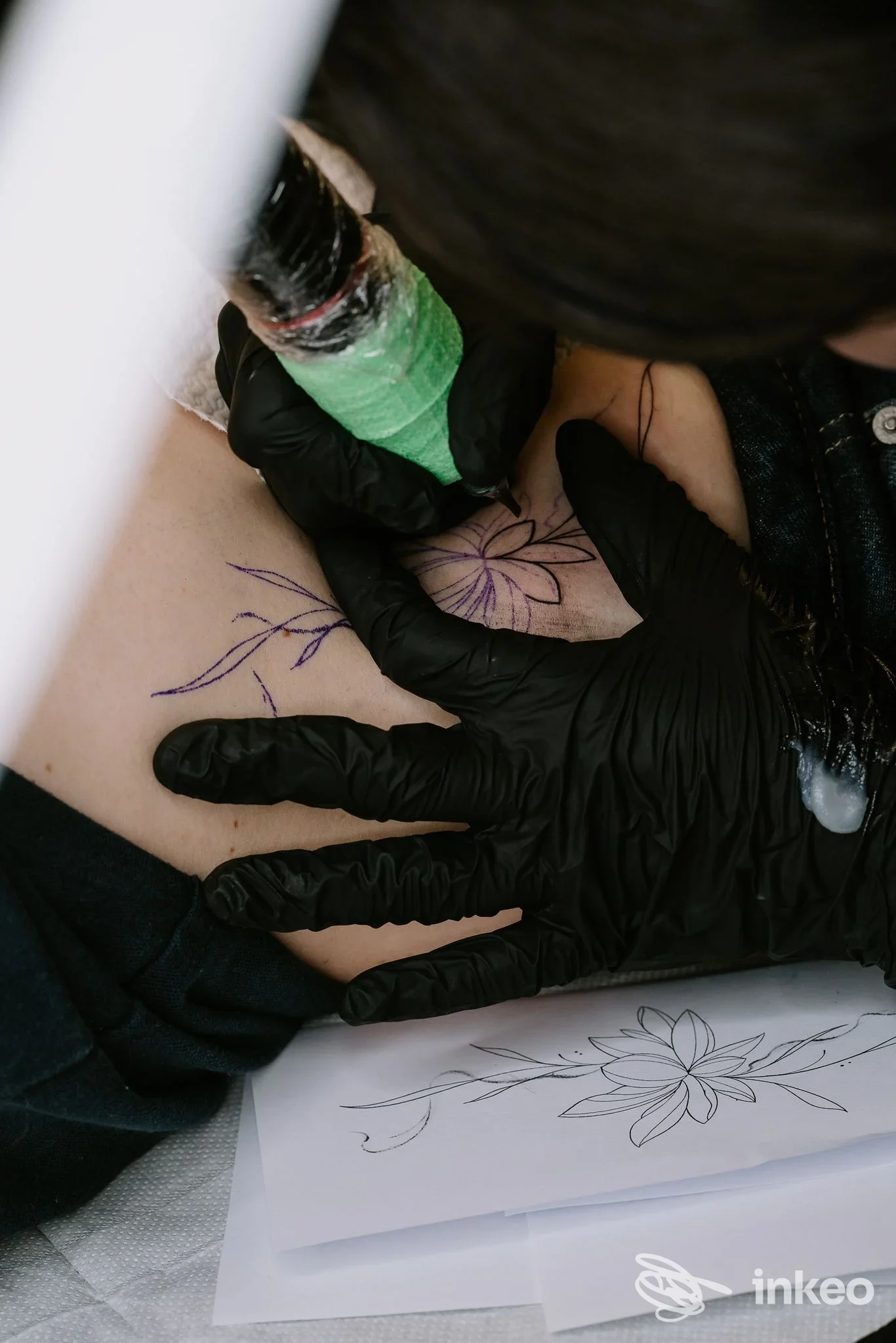 Operatrice che esegue un tatuaggio floreale sul petto, Accademia – More Than Tattoo, Rozzano.