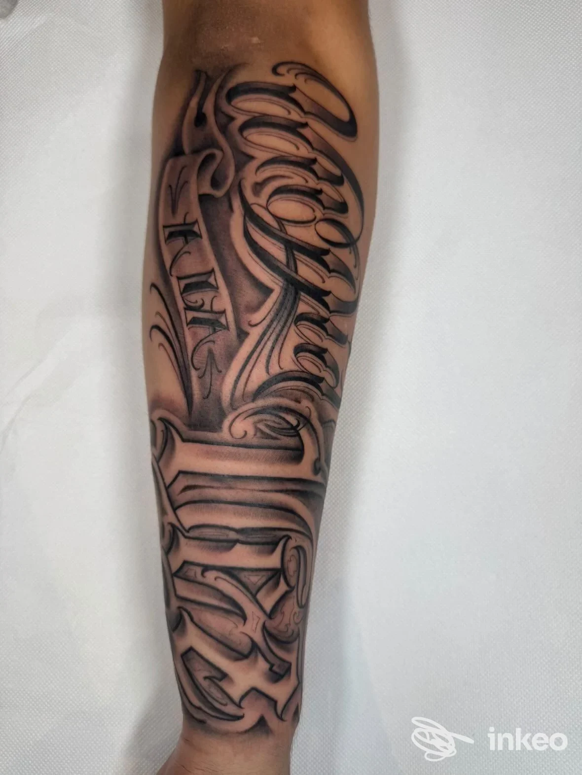 Tatuaggio a manica su avambraccio, stile linework nero/grigio, braccio visibile dall’alto al basso, senza volto in primo piano. The Culture Ink, Italia.