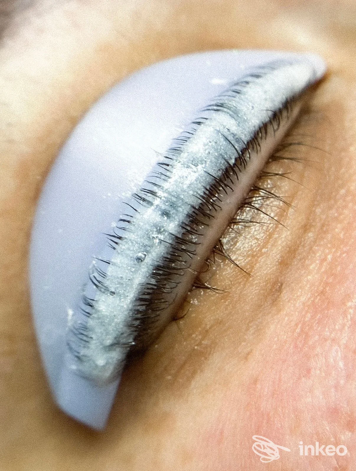 Primo piano di palpebra con permanente eyeliner in corso, residui di pigmento e supporto protettivo. Miriana Savino Make-up & Beauty Service, Venosa.