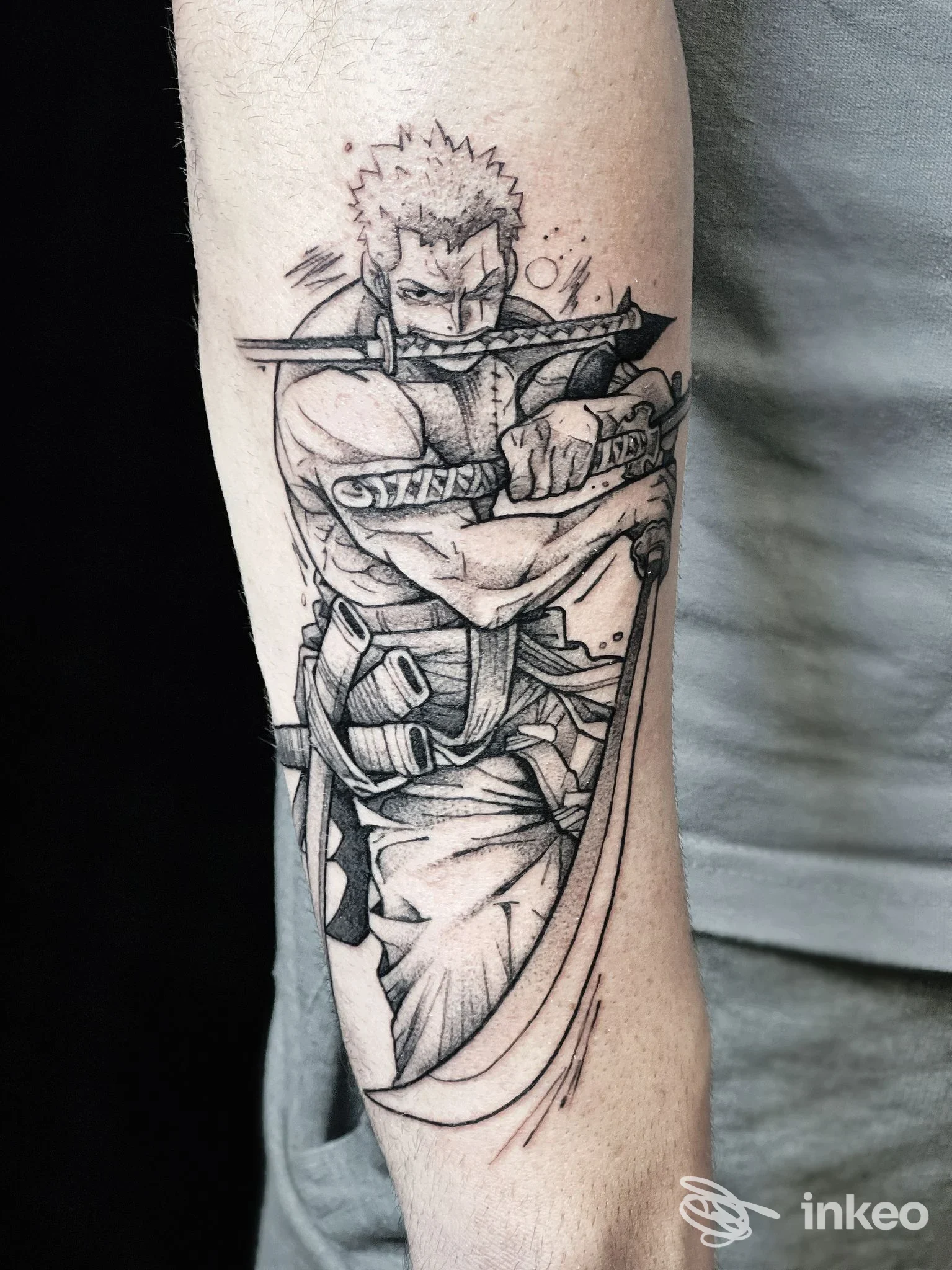 Tatuaggio in bianco e nero sull’avambraccio raffigurante un guerriero che brandisce una spada, esecuzione artistica dettagliata su pelle.