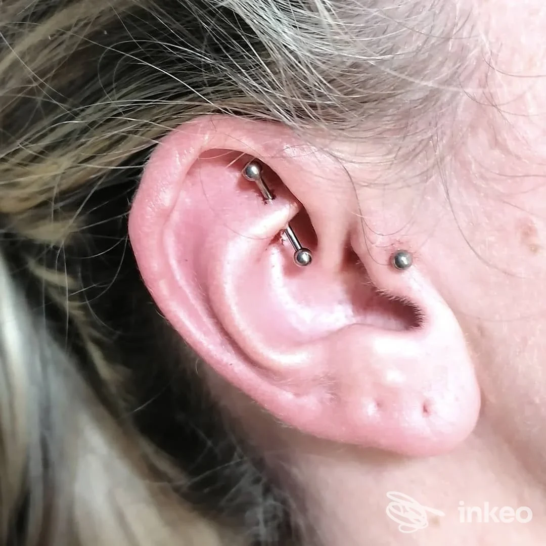 Primo piano di orecchio con industrial barbell e piercing, foto per Beauty & the Beast Tattoo Studio di Kia G., Mondovì.
