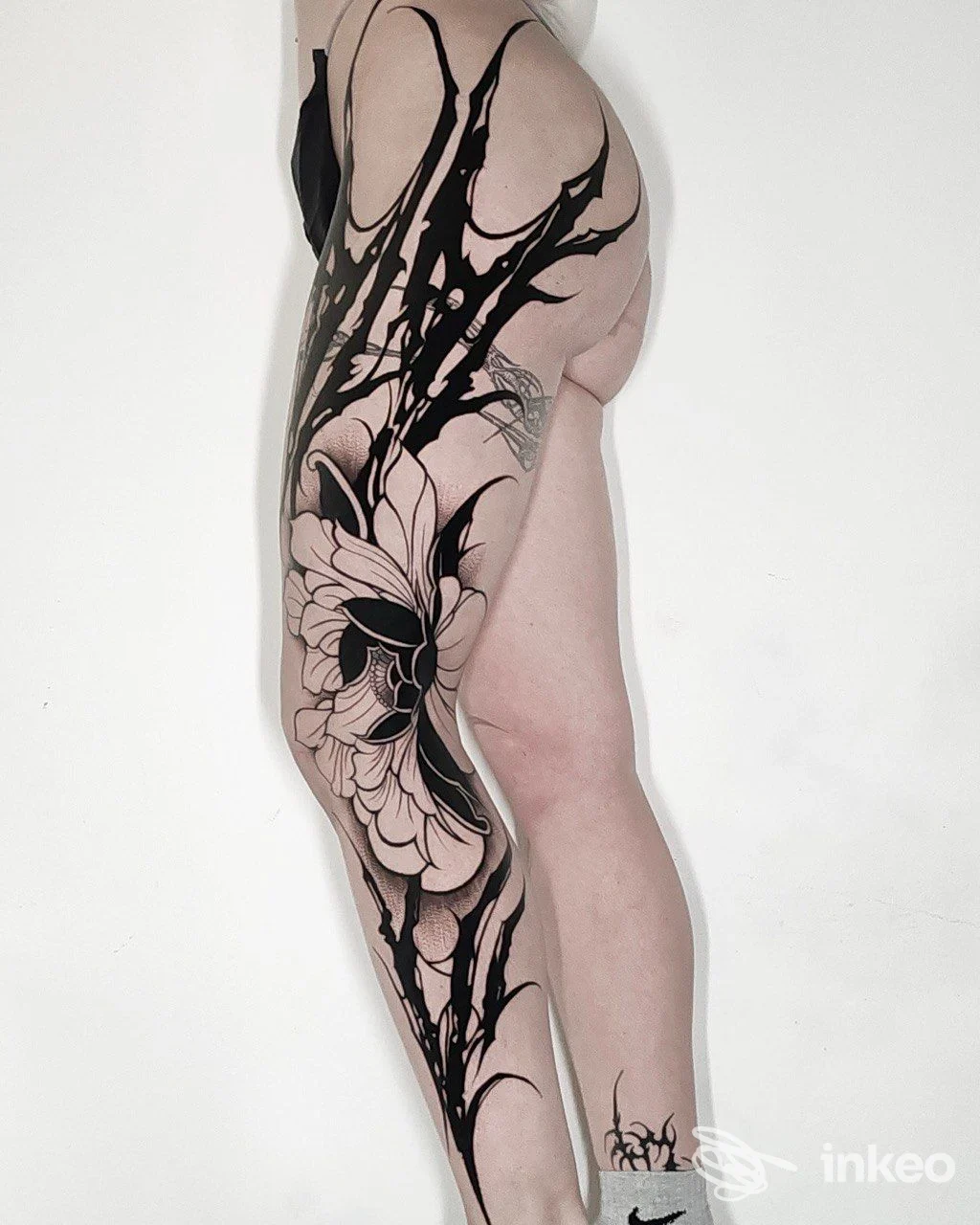 Grande tatuaggio blackwork sulla coscia e anca, fotografia di dettaglio per ALEX DE PASE STORES, Udine.