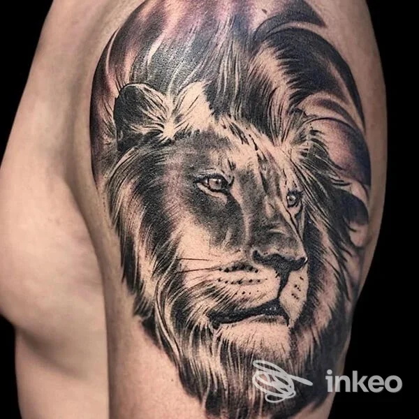 Tatuaggio realistico in bianco e nero a forma di testa di leone sul braccio, foto fornita da Tatuaggi Roma Nord - Fabio Brocca Tattoo, Roma