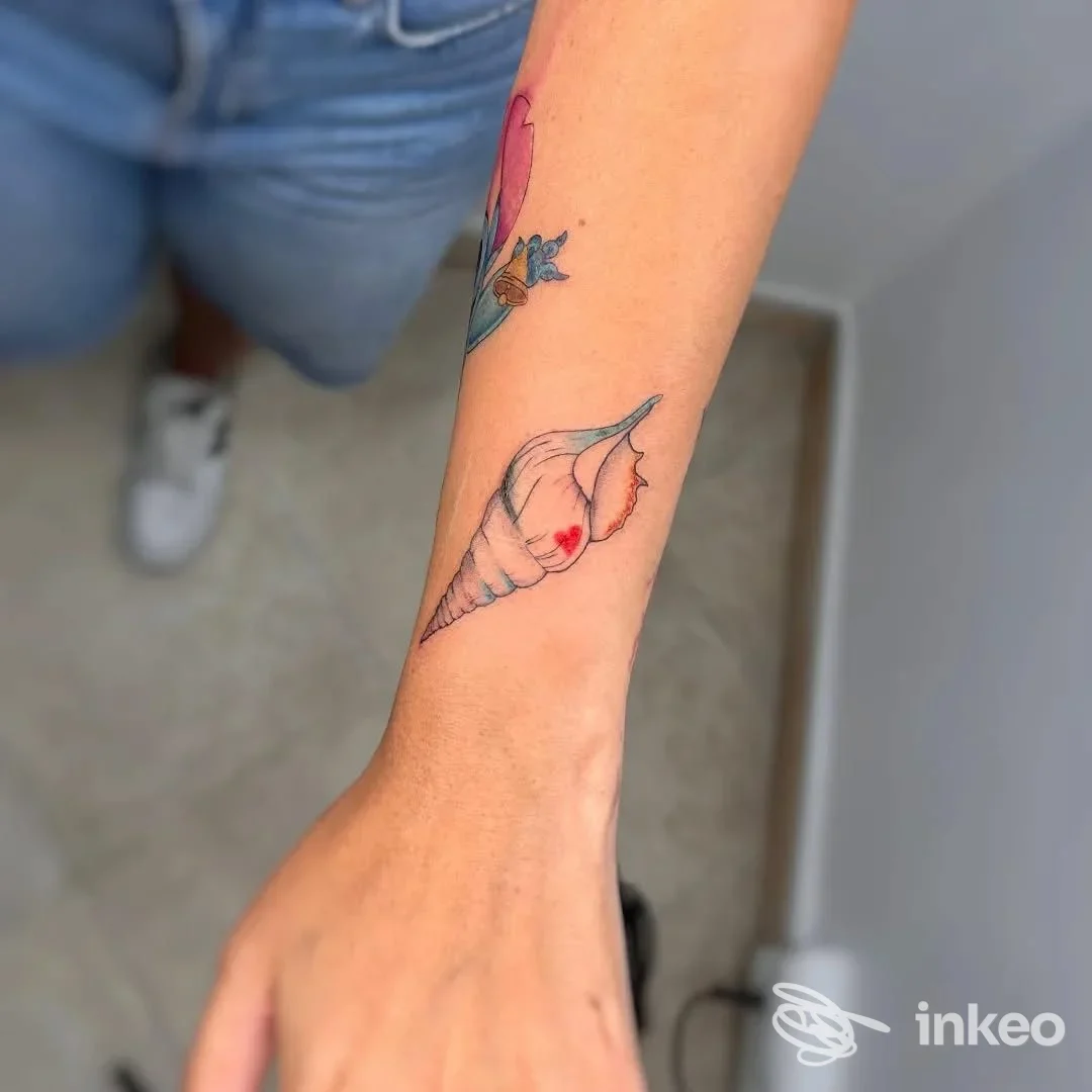 Tatuaggio conchiglia colorata sull'avambraccio, immagine fornita dallo studio Chiara Starace | Key Muse a Sanremo.