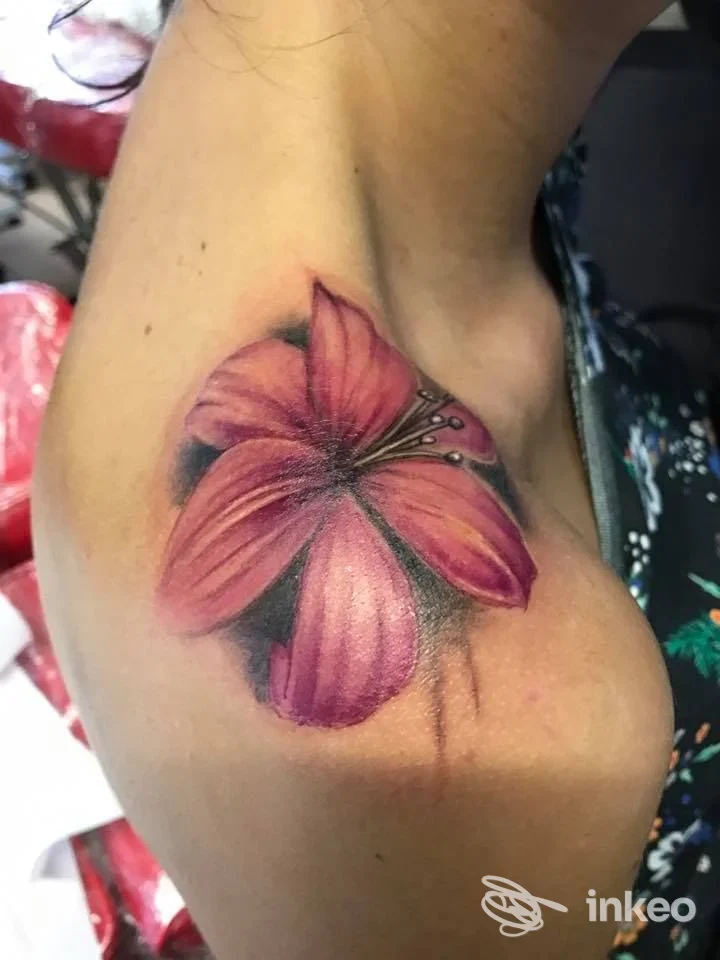 Tatuaggio floreale rosa sulla spalla, scatto che mostra il lavoro recente eseguito presso Studio Tatuaggi a Medesano.