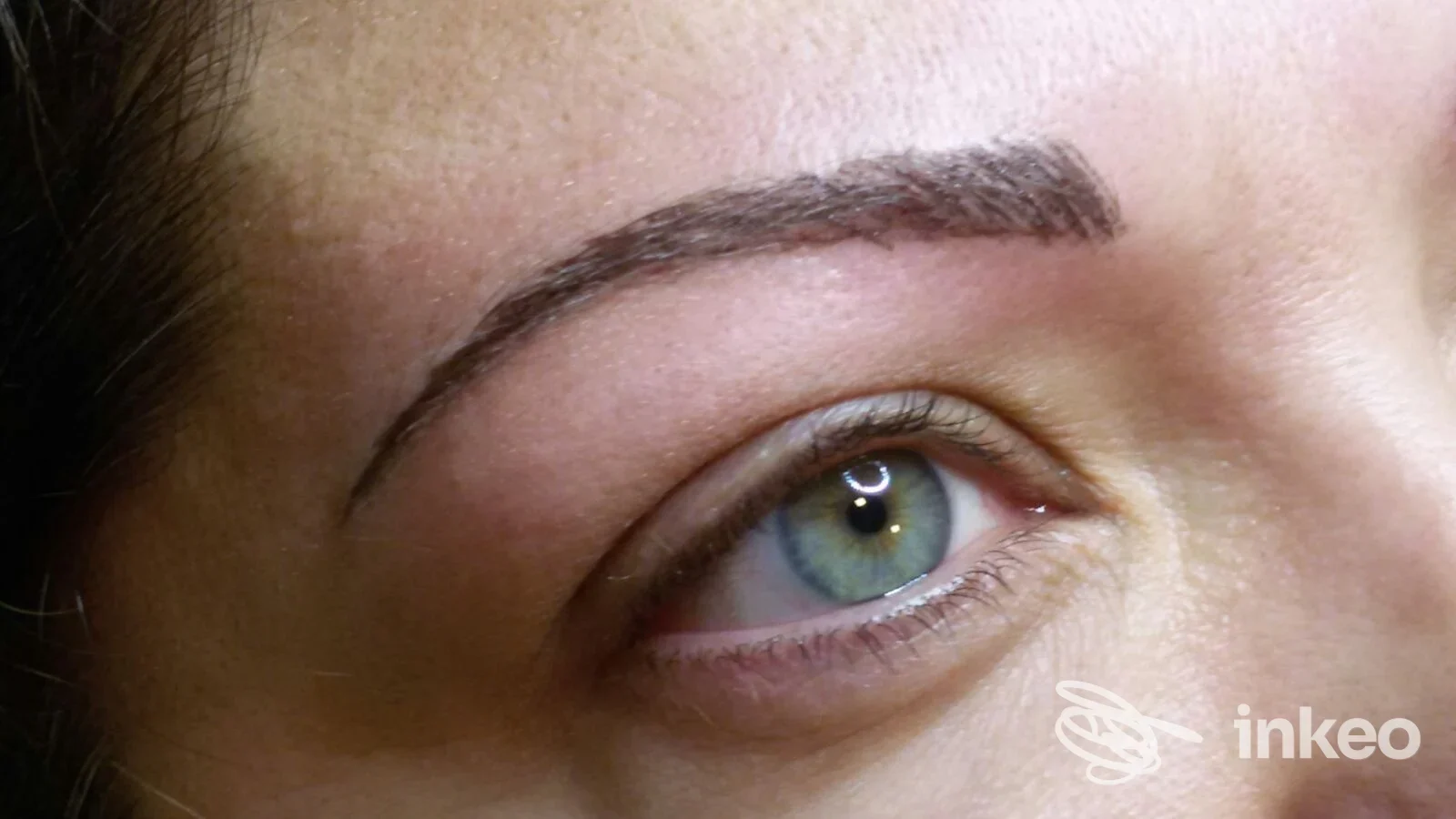 Primo piano di sopracciglio con trucco permanente (tricopigmentazione) su pelle reale; scatto per Maison De Charme a Genova, centro estetico.