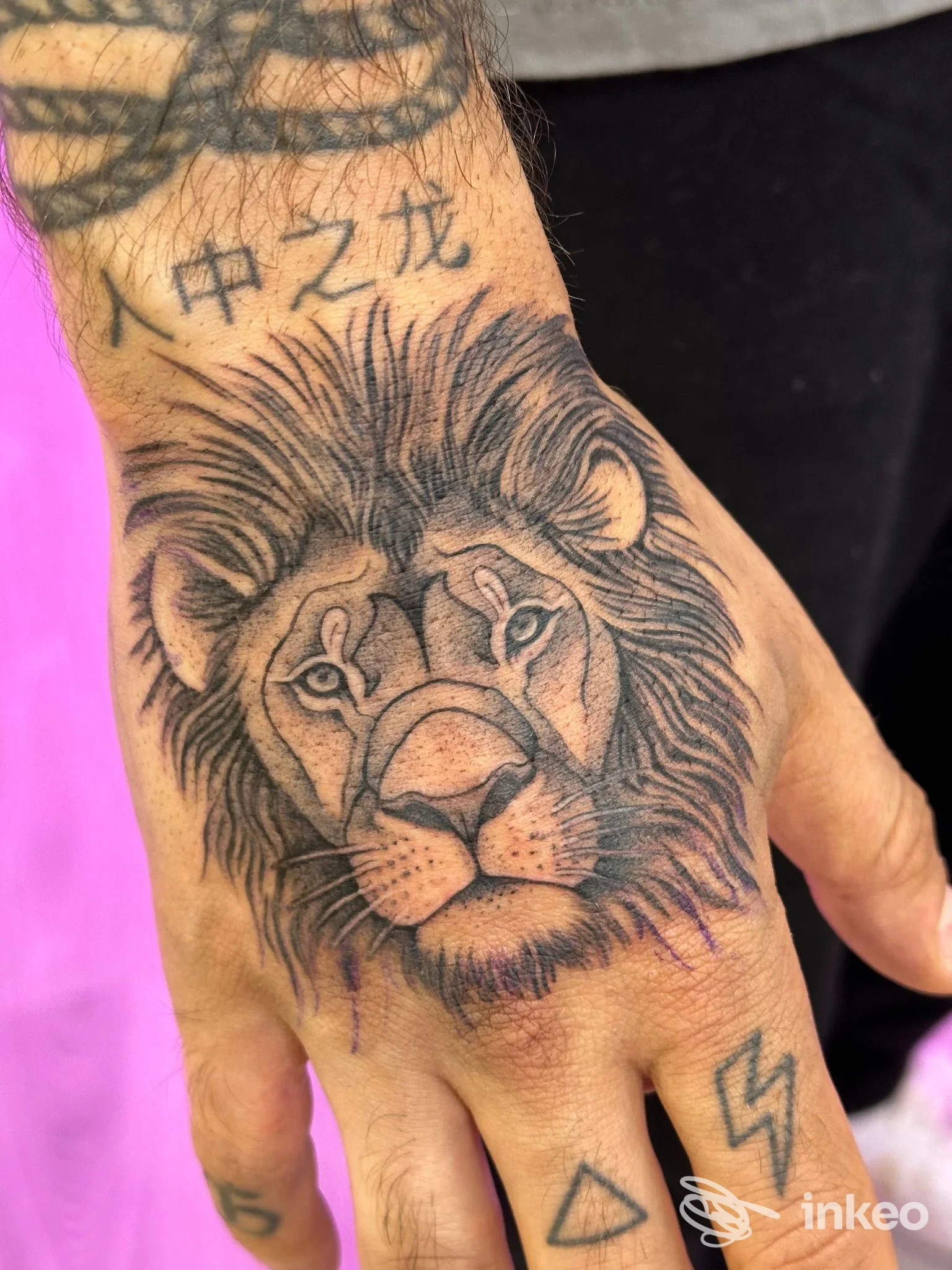 Tatuaggio di un leone realistico sul dorso della mano, foto inviata da Baltica Tattoo a Roma.