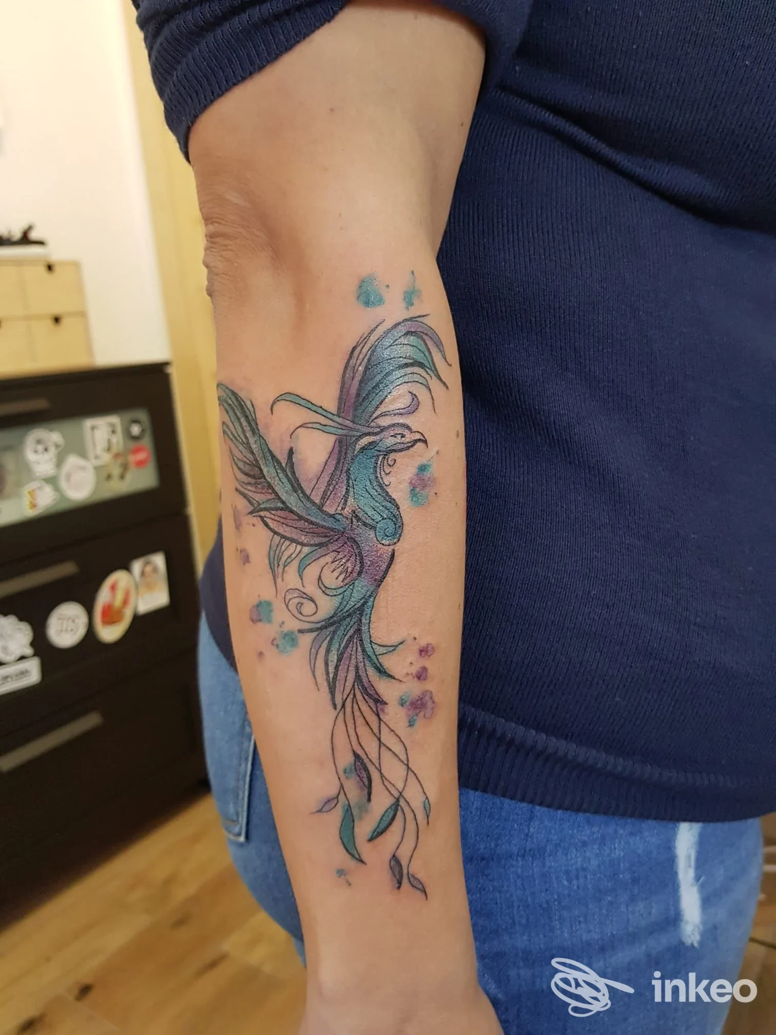 Tatuaggio colorato a forma di uccello stilizzato sull'avambraccio, foto fornita da Stella Caos Ink, La Spezia.