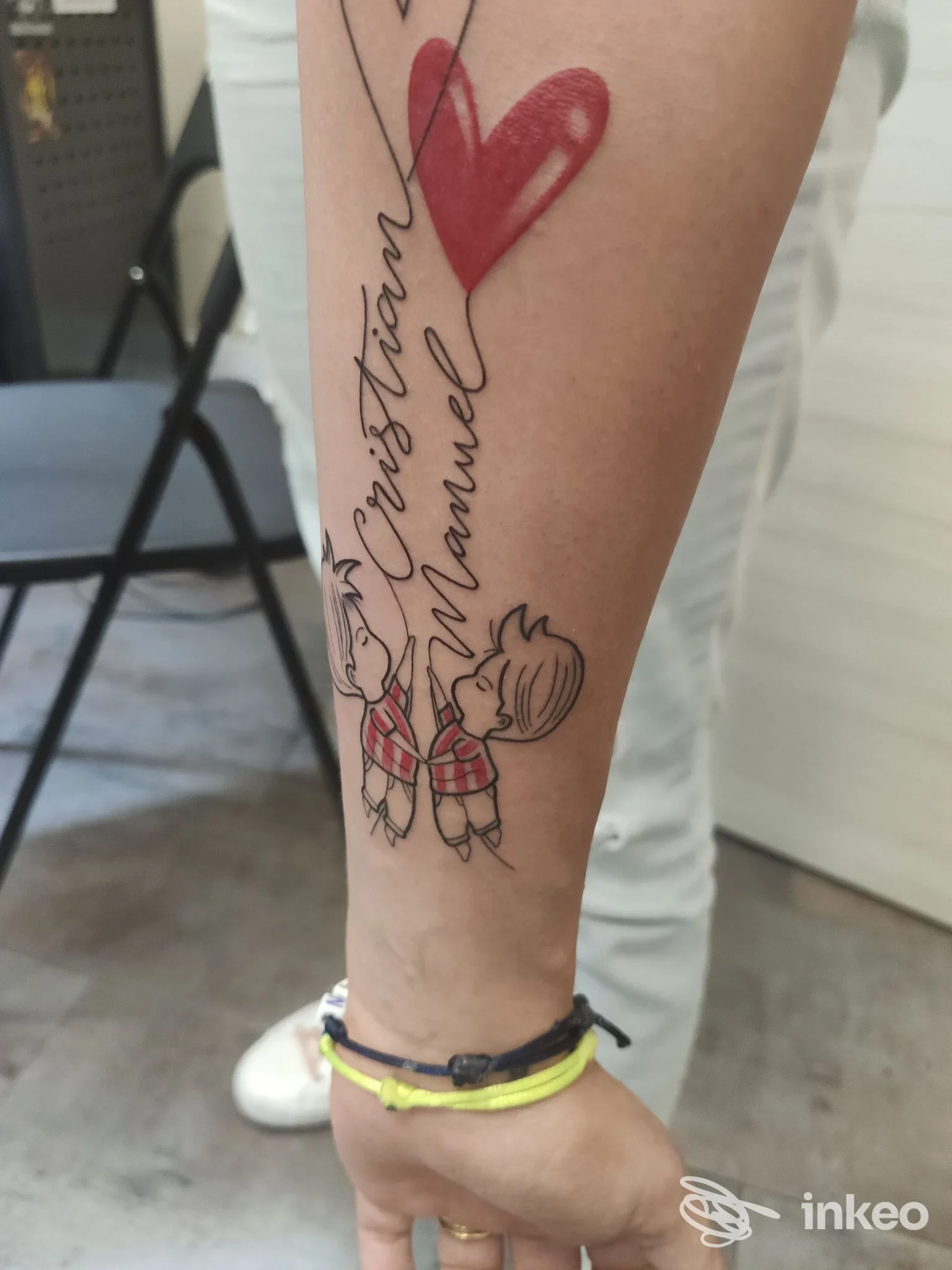 Tatuaggio sull'avambraccio con cuore rosso e due bambini stilizzati, foto Black Lantern Tattoo Studio, Roma.