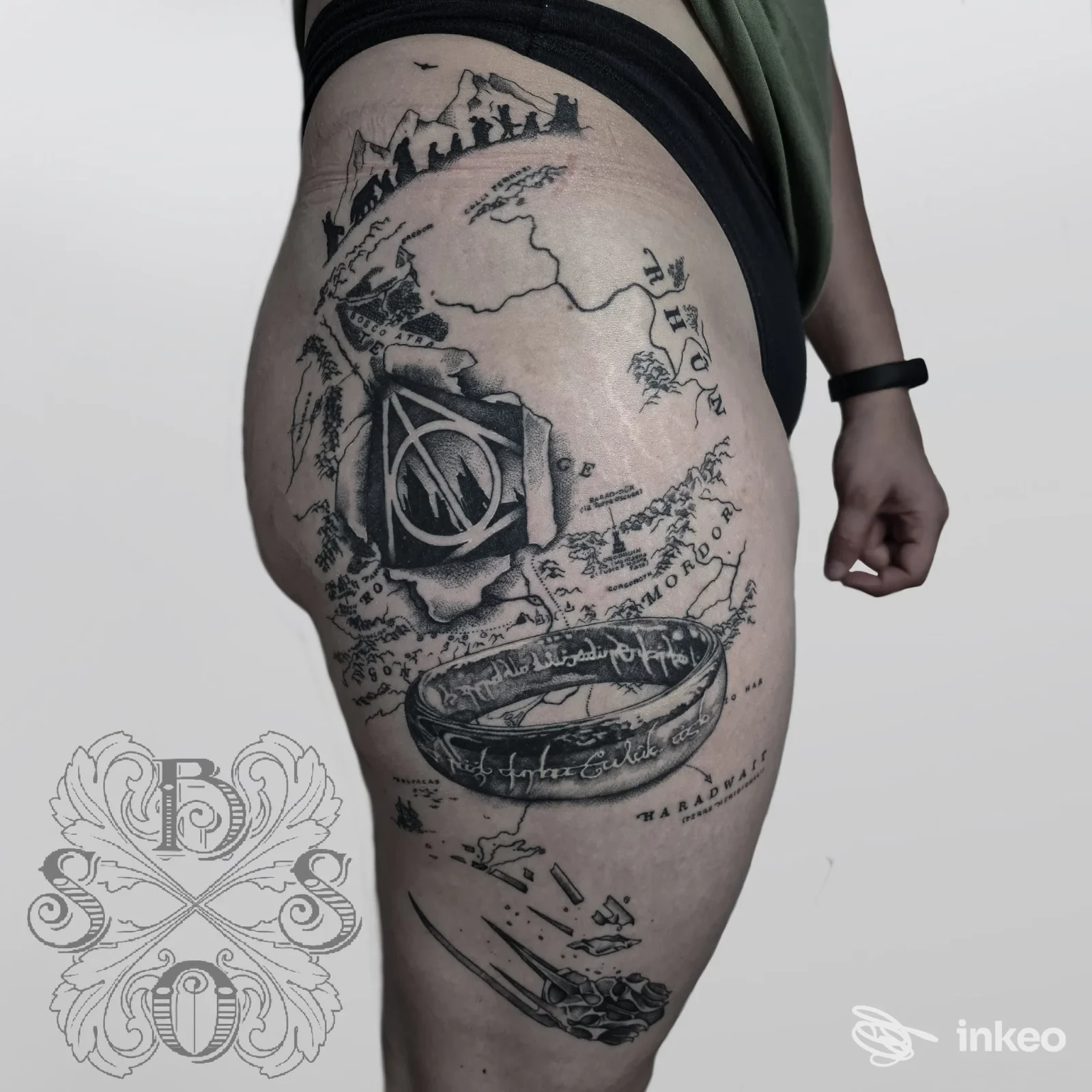 Tattoo in bianco e nero sulla coscia sinistra, design complesso con elementi grafici, visibile su una gamba di una persona.