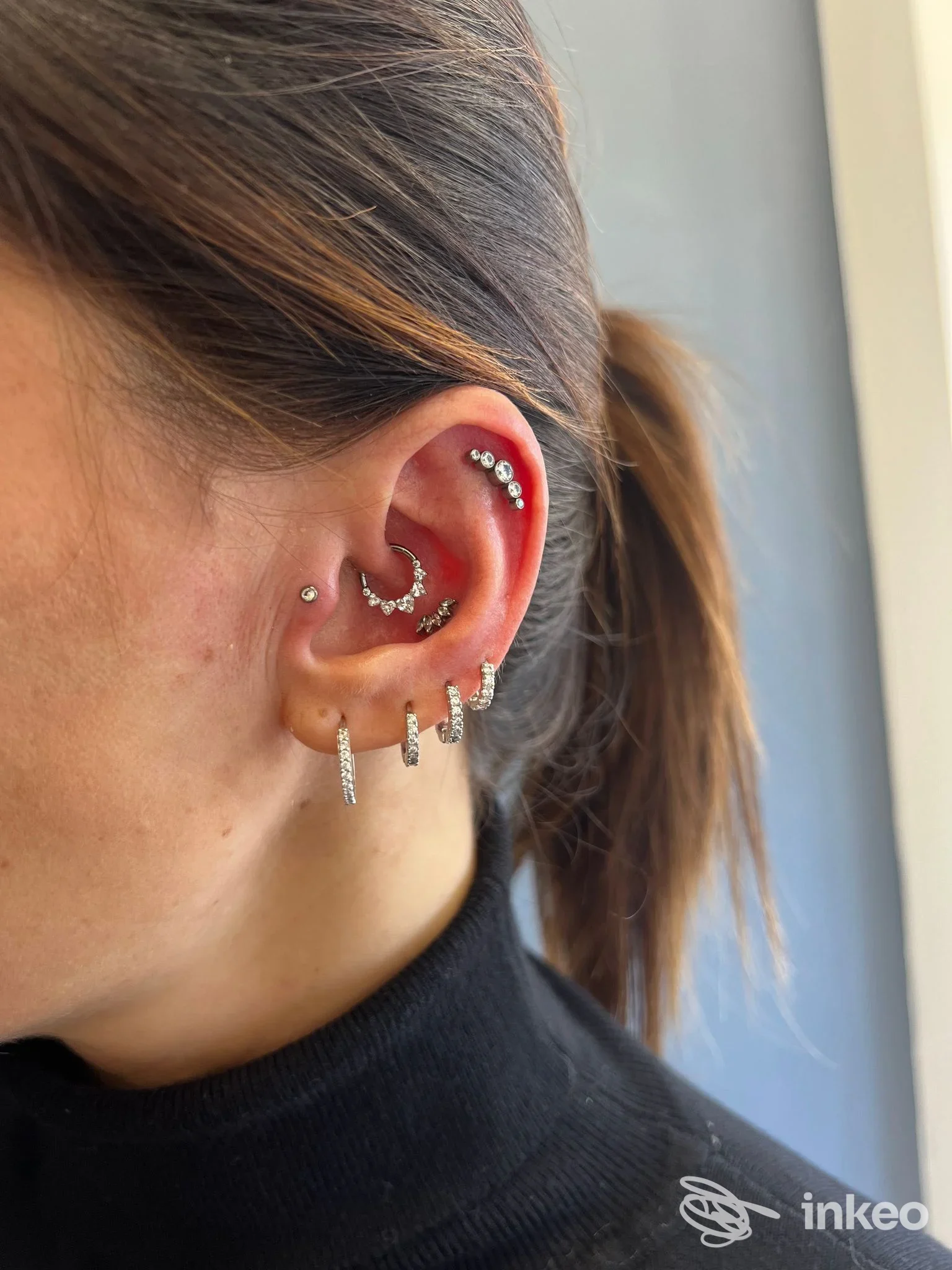 Primo piano dell'orecchio con diversi piercing in cartilagine e lobo, foto fornita da EsteticaMente, Rieti.