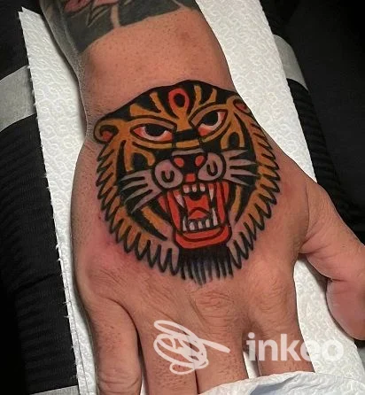 Fotografia di una testa di tigre tatuata sul dorso della mano, realizzata da The Grim Reaper Tattoo, Roma. Colori pieni e contorni netti.