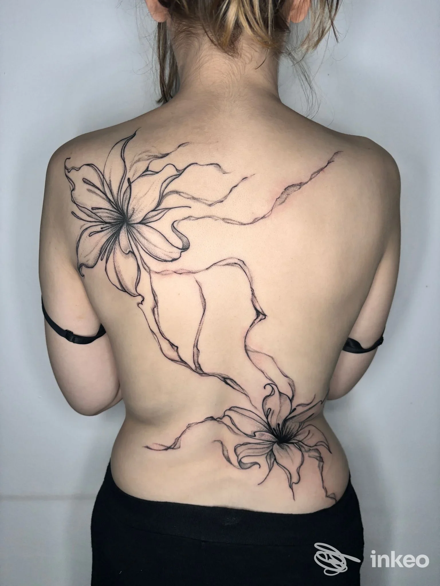 Grande tatuaggio floreale sulla schiena, dal lato della spalla sinistra fino alla zona lombare — Louis Studio, Torino.