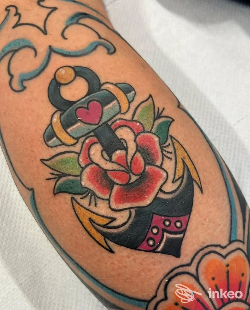 Tatuaggio in stile old school raffigurante un'ancora con cuore e rosa sul lato interno dell'avambraccio, fotografia per Bohemia Body Art, Galatina.