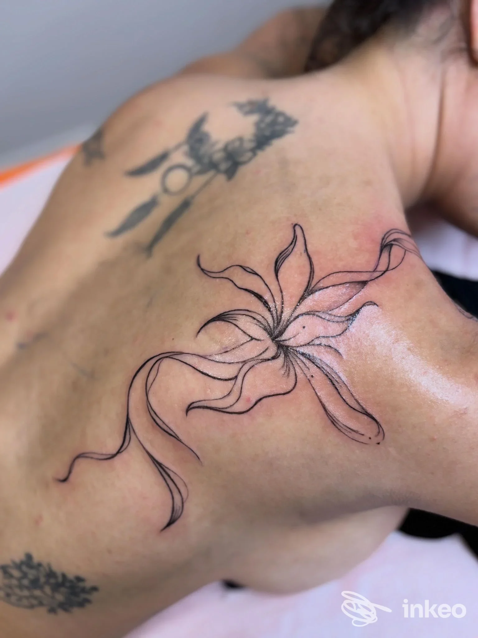 Tatuaggio floreale a linee sottili sulla spalla/parte superiore della schiena, scatto di Alessandra Trasatti | Beauty Artist, Fermo.