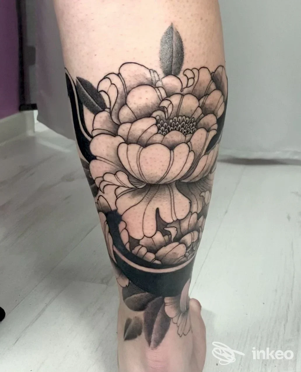 Grande tatuaggio floreale in nero sul polpaccio, foto dello studio Skin Beauty Estetica e Tattoo by abbronzatissimi a Senigallia.