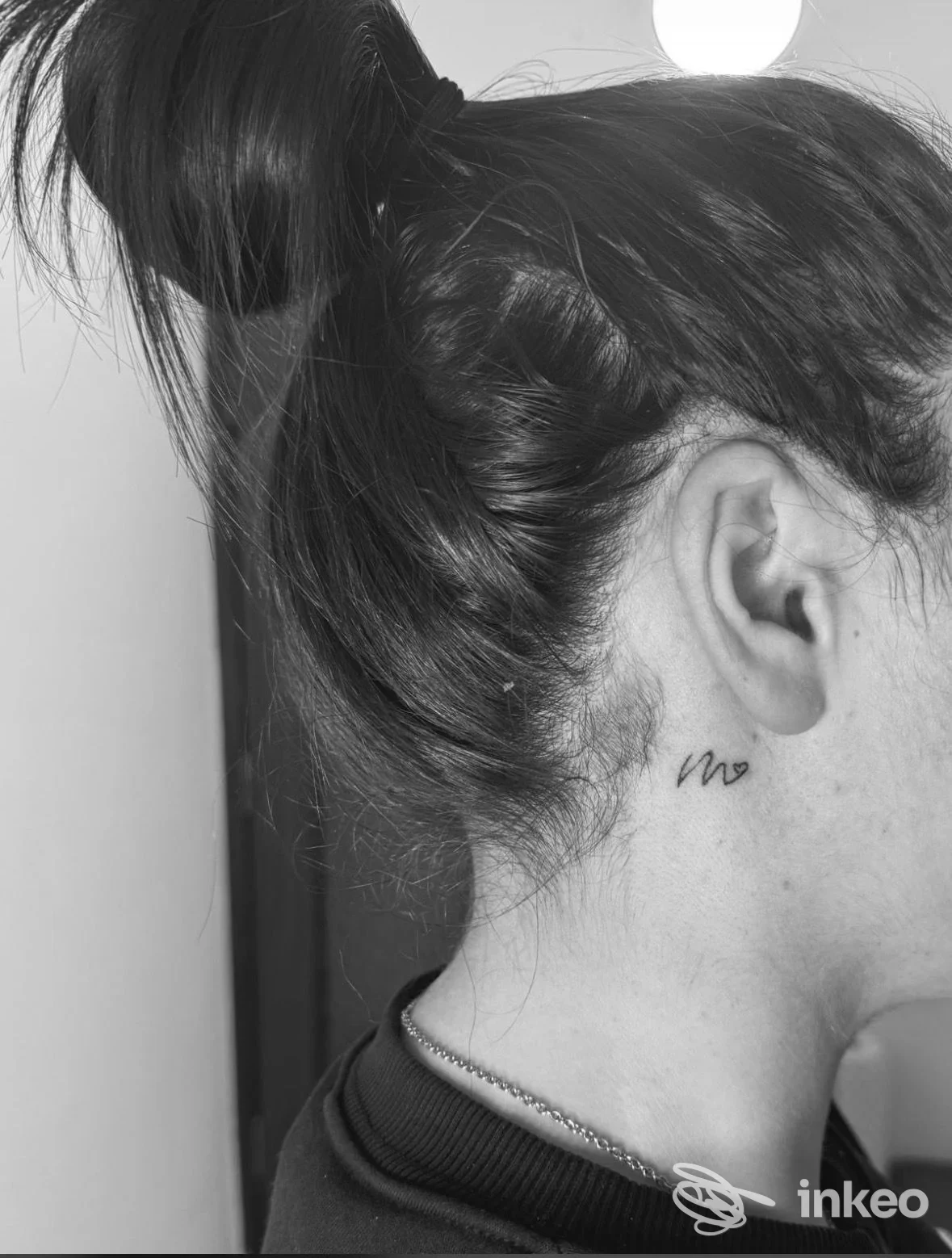 Primo piano di un piccolo tatuaggio dietro l'orecchio realizzato da BeautyInk by Federica a Faggiano.