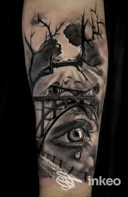Tatuaggio realistico in bianco e nero su avambraccio con occhio che piange, ponte e sagome tra rami — Orlando Tattoo e Piercing Studio, Taurisano.